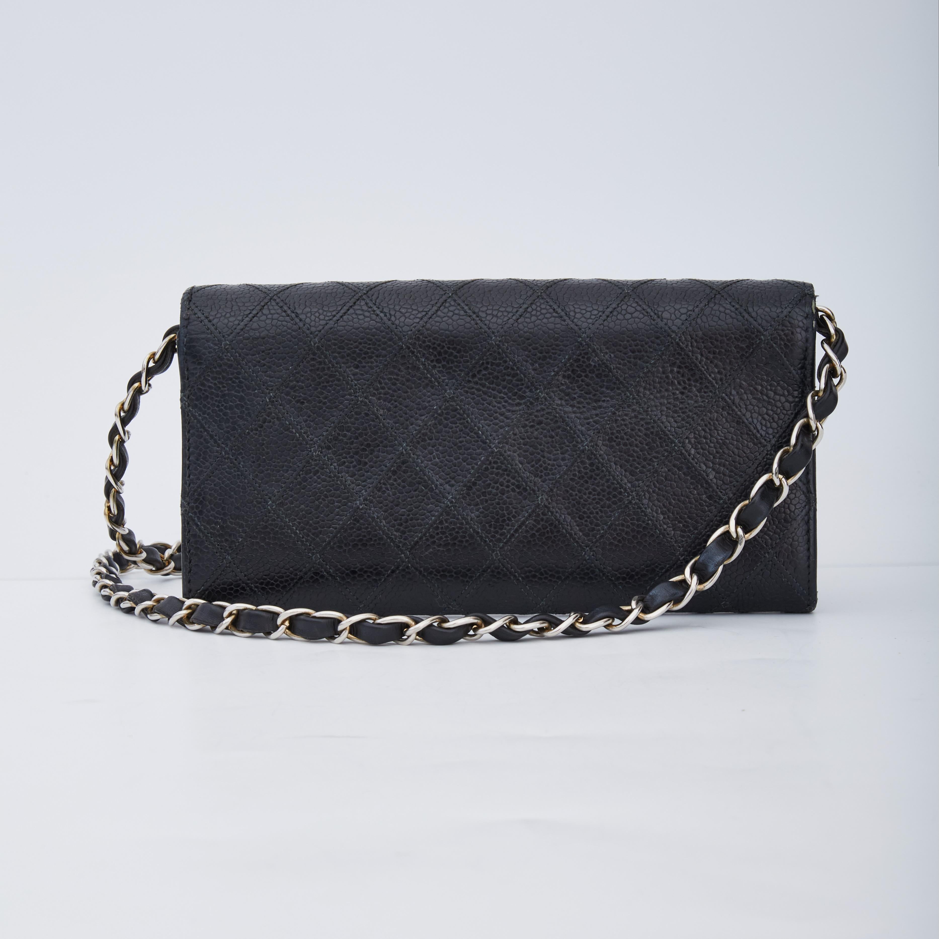 This classic Chanel WOC bag is made of caviar leather in black with sliver tone hardware. The bag features a logo at front, flap closure with snap, a chain interlaced with leather shoulder strap, a portioned interior with car slots and black fabric