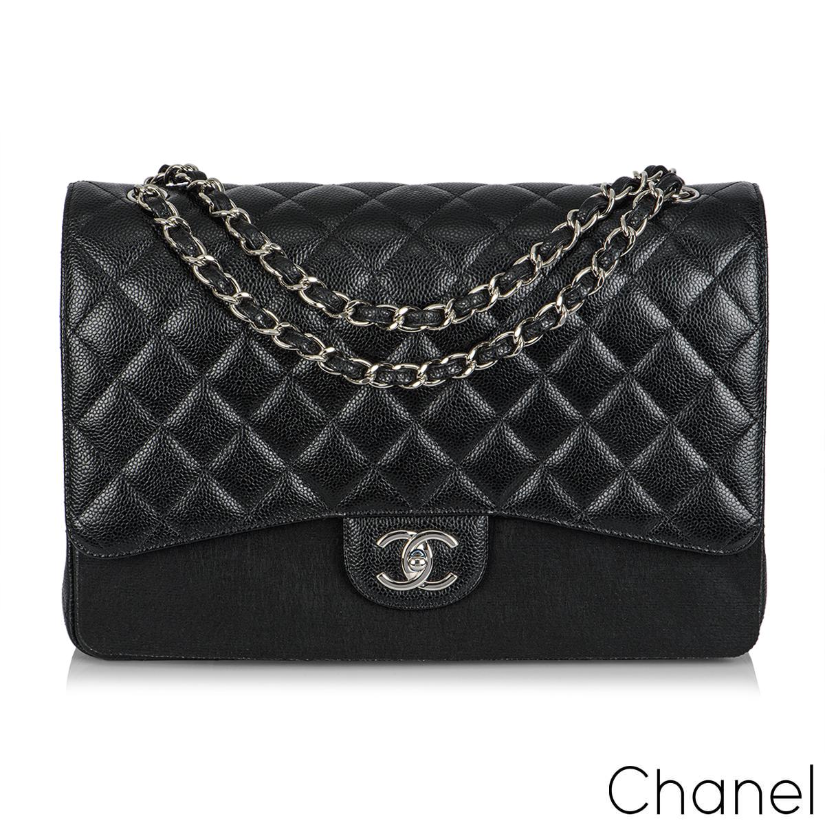 A timeless Chanel Classic Double Flap Handbag. The exterior of this Maxi classic is in black caviar leather with silver tone hardware. It features a front flap with signature CC turnlock closure, half moon back pocket, an adjustable interwoven