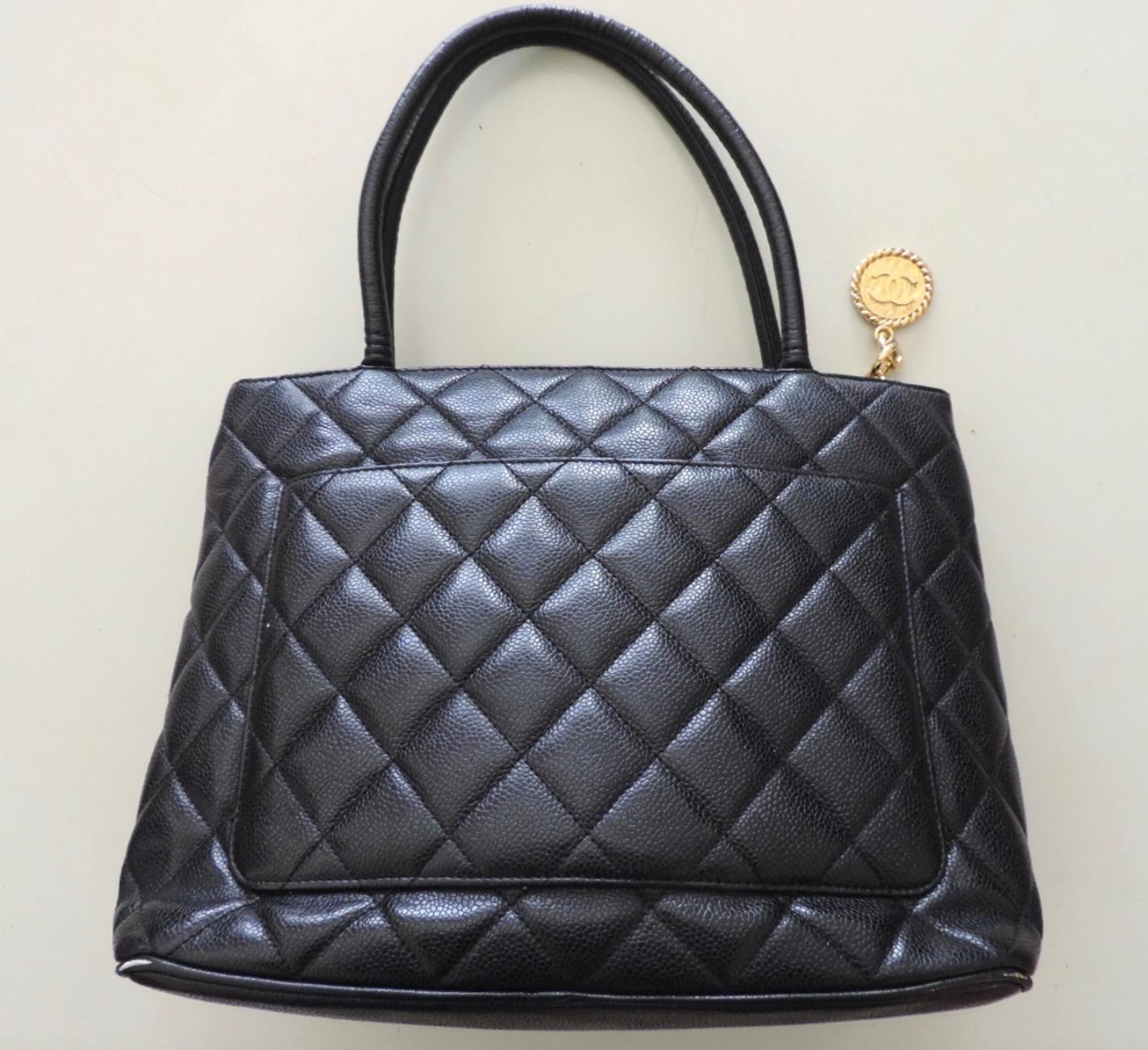 Vintage black Chanel Médallion tote in good pre-owned condition. The Chanel Medallion Tote was produced in one size and measures approximately 12.5 inches in width, 10 inches in height, and 6 inches in depth, with a 6.5-inch handle drop. It was