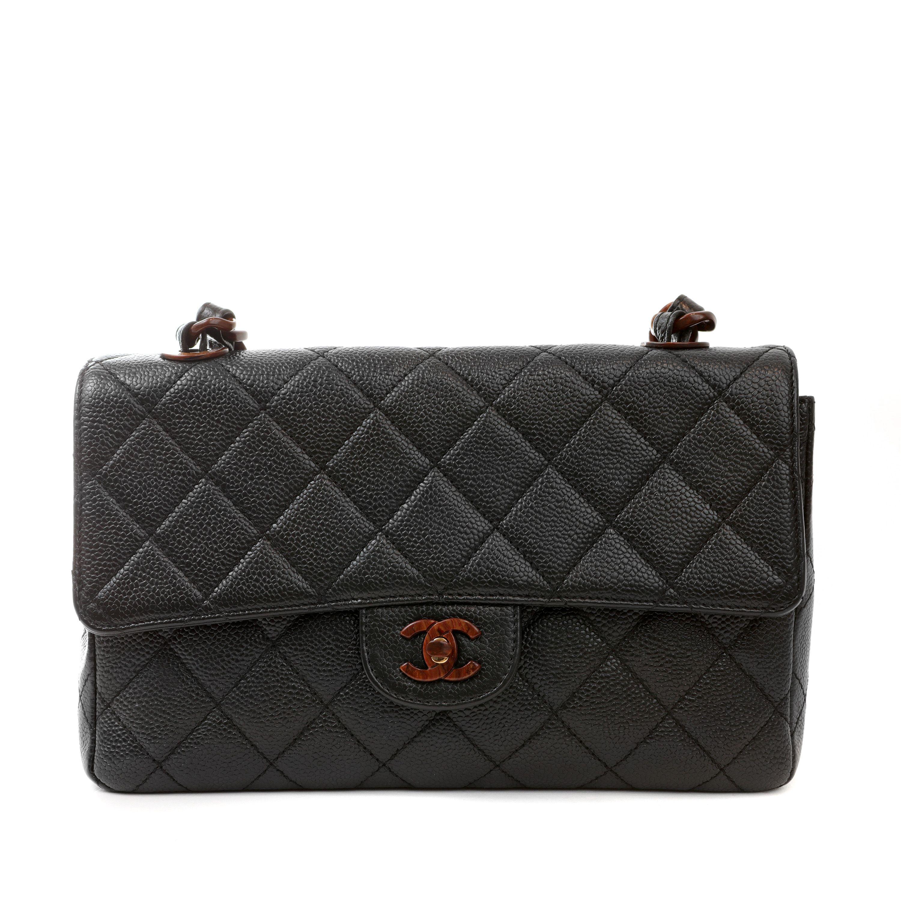 This authentic Chanel Black Caviar Medium Classic Flap with Burled Wood Hardware is in excellent condition.  Rare and collectible, this Classic has extremely rare contrasting wood CC clasp and intertwined strap. Dust bag included. 
Measurements: