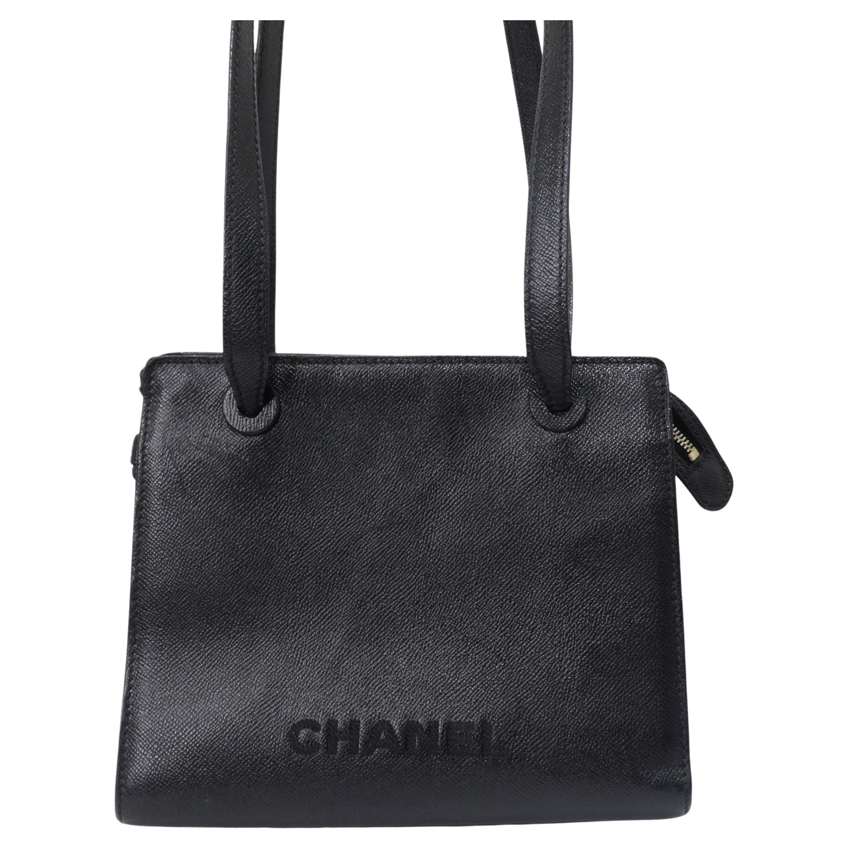 Simple and timeless black Chanel shoulder bag circa late 1990s. This is a great staple piece for anyone on the market for a new every day handbag that will match with every outfit and fit all of your belongings without weighing you down! Featuring a