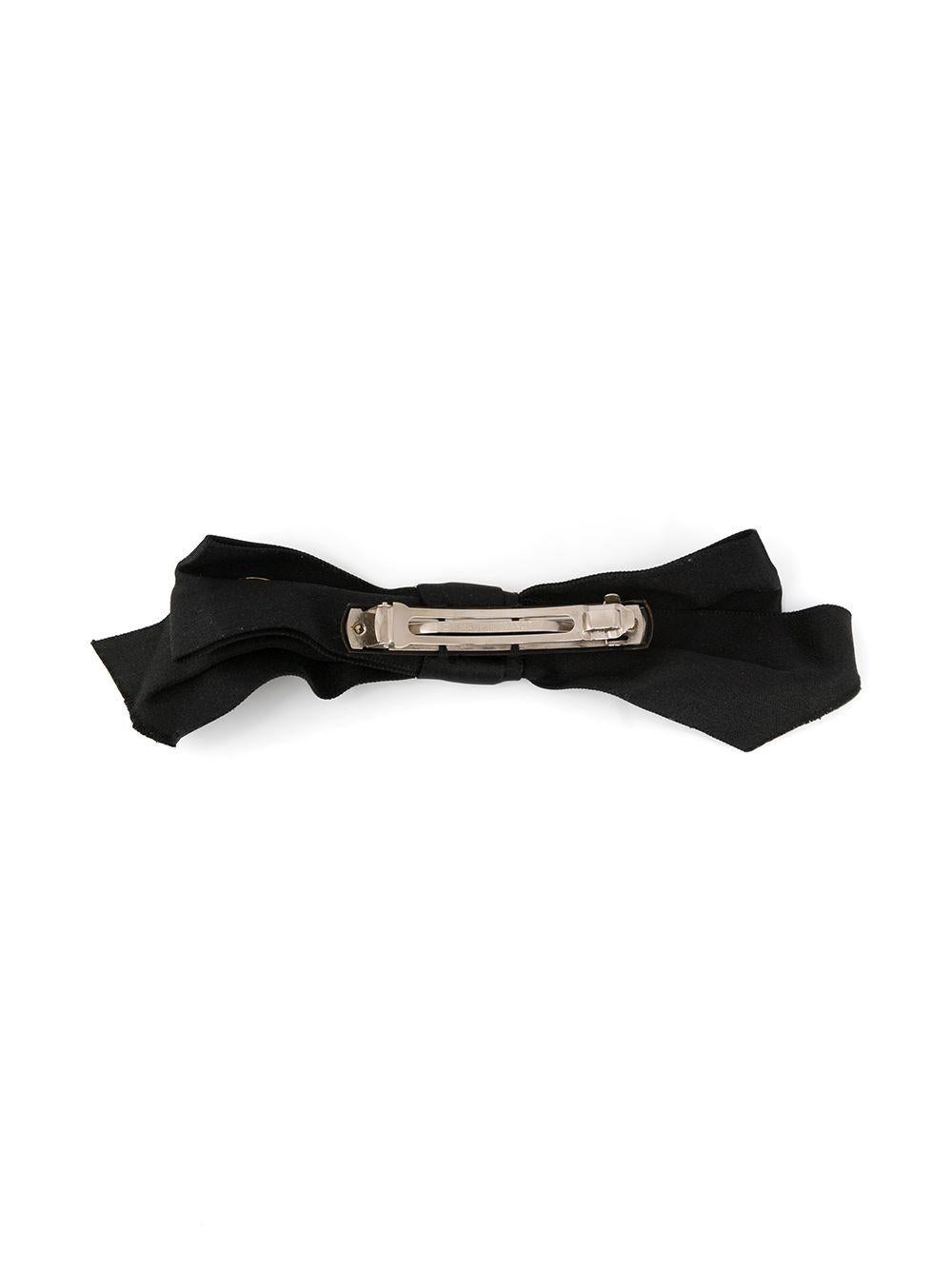 Add a youthful, preppy vibe to your look with this pre-owned black silk hair barrette from Chanel. Crafted in France, this elegant accessory boasts a smooth matte finish, a slim, rectangular shape and a silver-tone metal clasp fastening. For an