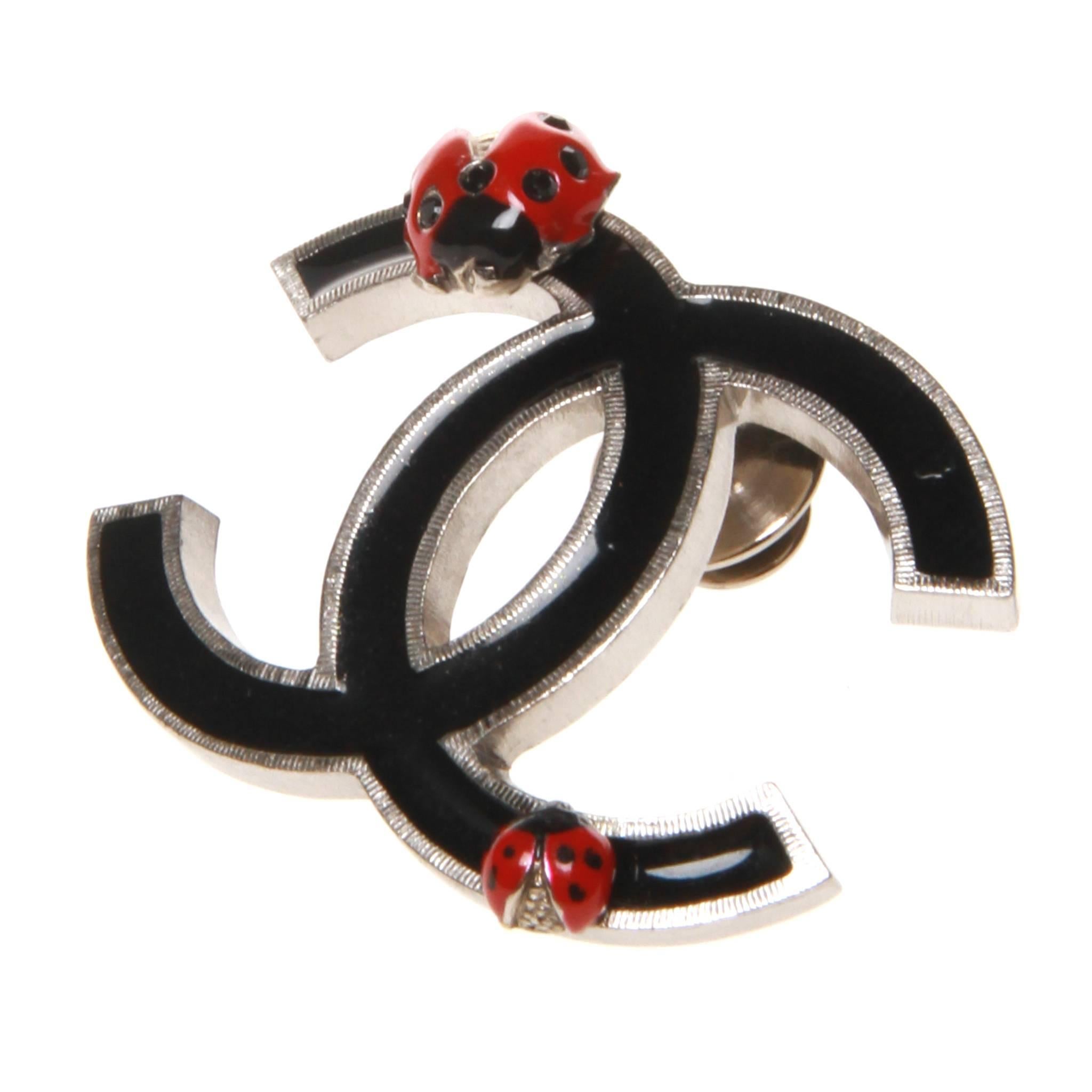 Chanel iconic interlocking CC brooch of black enamel in a silver-tone setting featuring two lady bugs. 

Comes with box. 

Stamped 04 P - Spring 2004