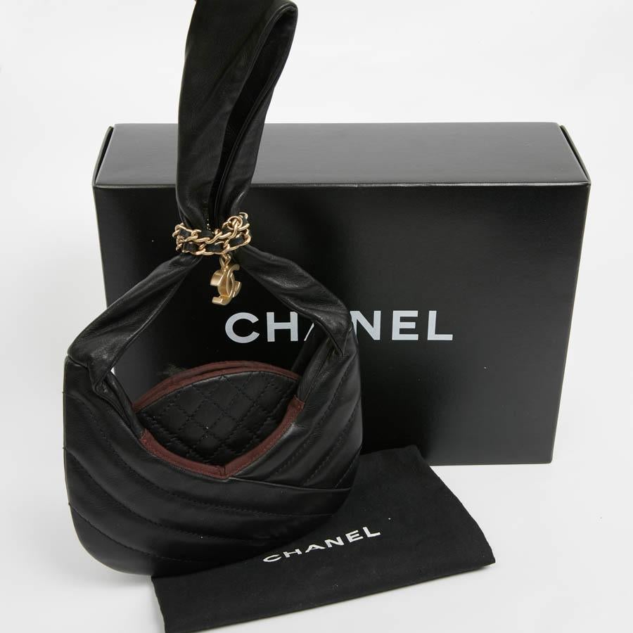 Rare small CHANEL in black leather lined with burgundy fabric. It is worn by hand. The chaplain is made in several evenings. A small padded pocket in the middle with a patch pocket on each side. A real gem, it does not close, the chain intertwined