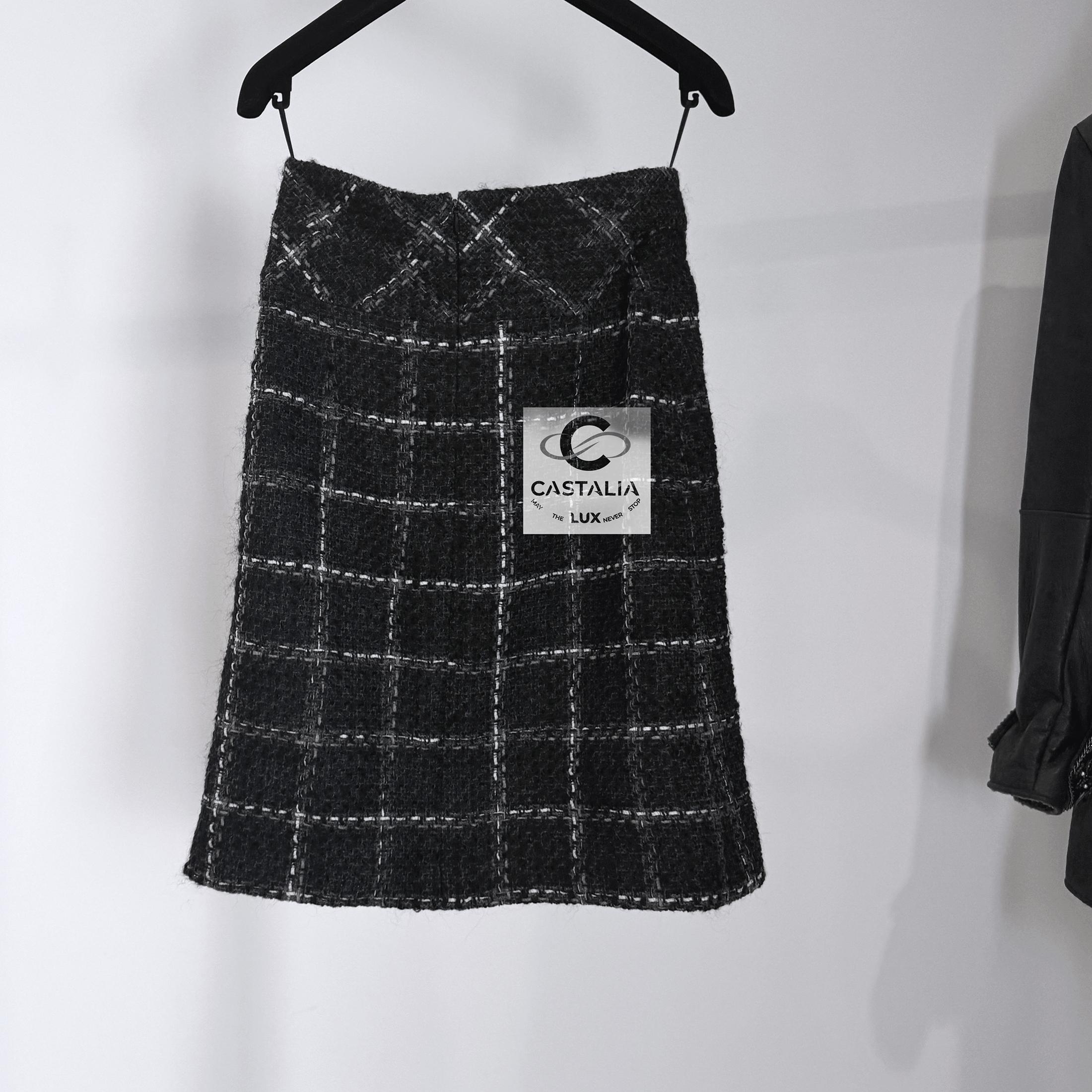 Chanel black checked tweed skirt with CC charm at waist 
- black silk lining
Size mark 34
Condition: kept unworn, condition of a new 