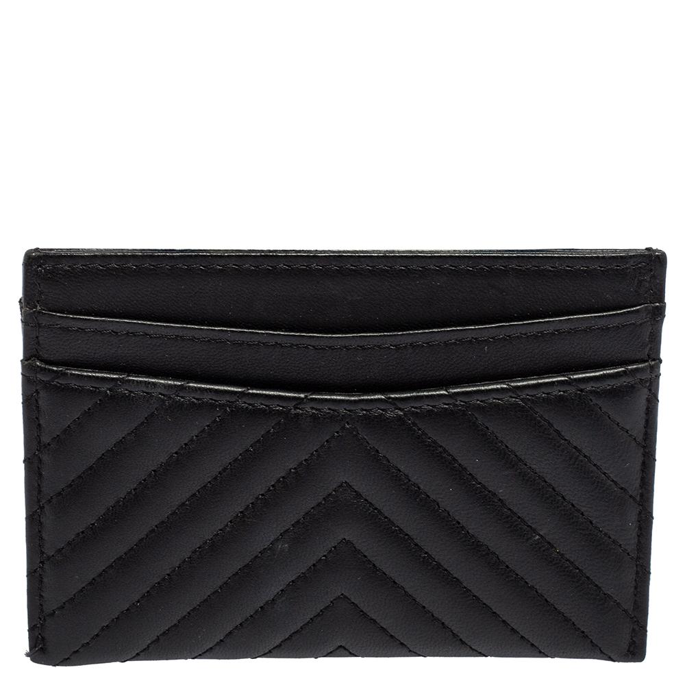 Crafted from quality leather, it carries a classic shade of black and a chevron quilt pattern. It is styled minimally with just the right elements to deliver a luxe appeal. The accessory is finished with the CC logo at the front.