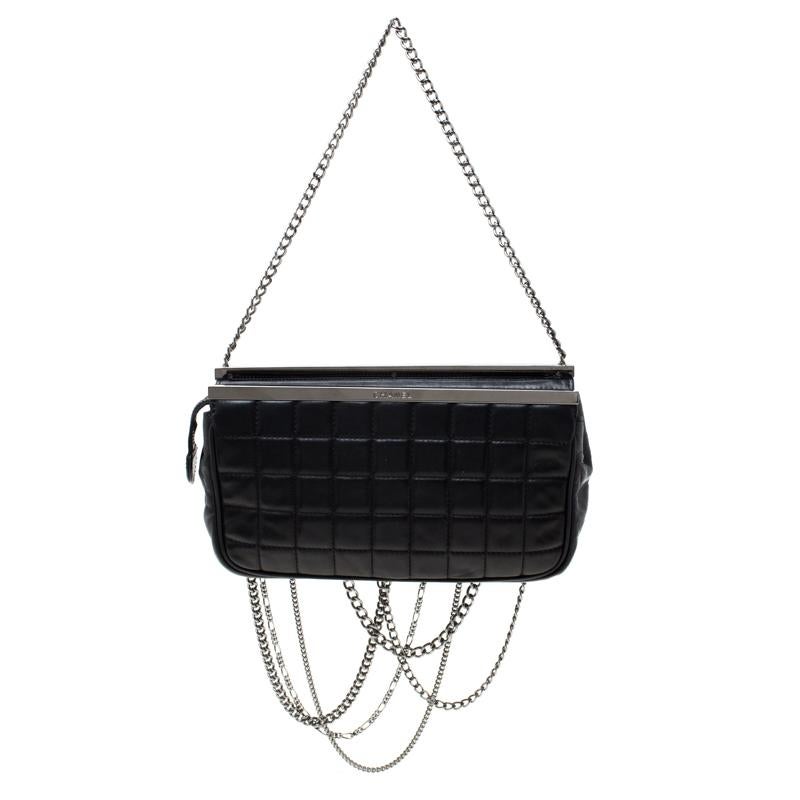 A clutch to complement both Chanel lovers and handbag admirers is this one. It is made from leather and features the chocolate bar quilt on the exterior. The clutch has dangling chains on the front, metal bars on top and a zipper that secures the