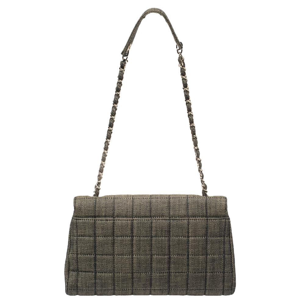 Made from black denim, this stylish Chanel bag is an all-rounder. Its exterior is stitched with the square pattern shaped like chocolate bars, coupled with silver-tone CC-engraved plates on the side of the front snap-enclosed flap. Its chain and