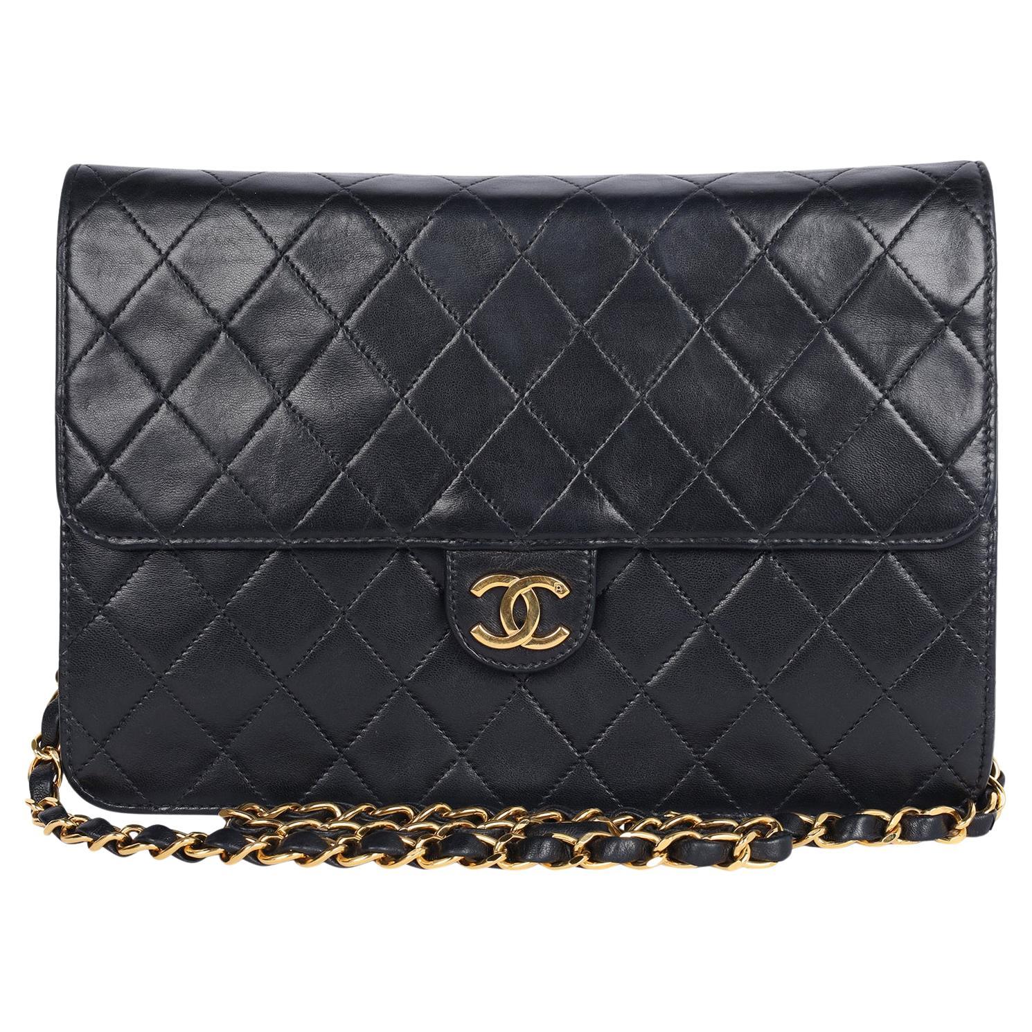 Authentic, pre-loved black lambskin leather Chanel classic single flap snap closure bag. Features front flap closure with CC snap closure, lambskin leather, large interior with zipper slip pocket, long gold weaved leather chain, 24 kt gold plated