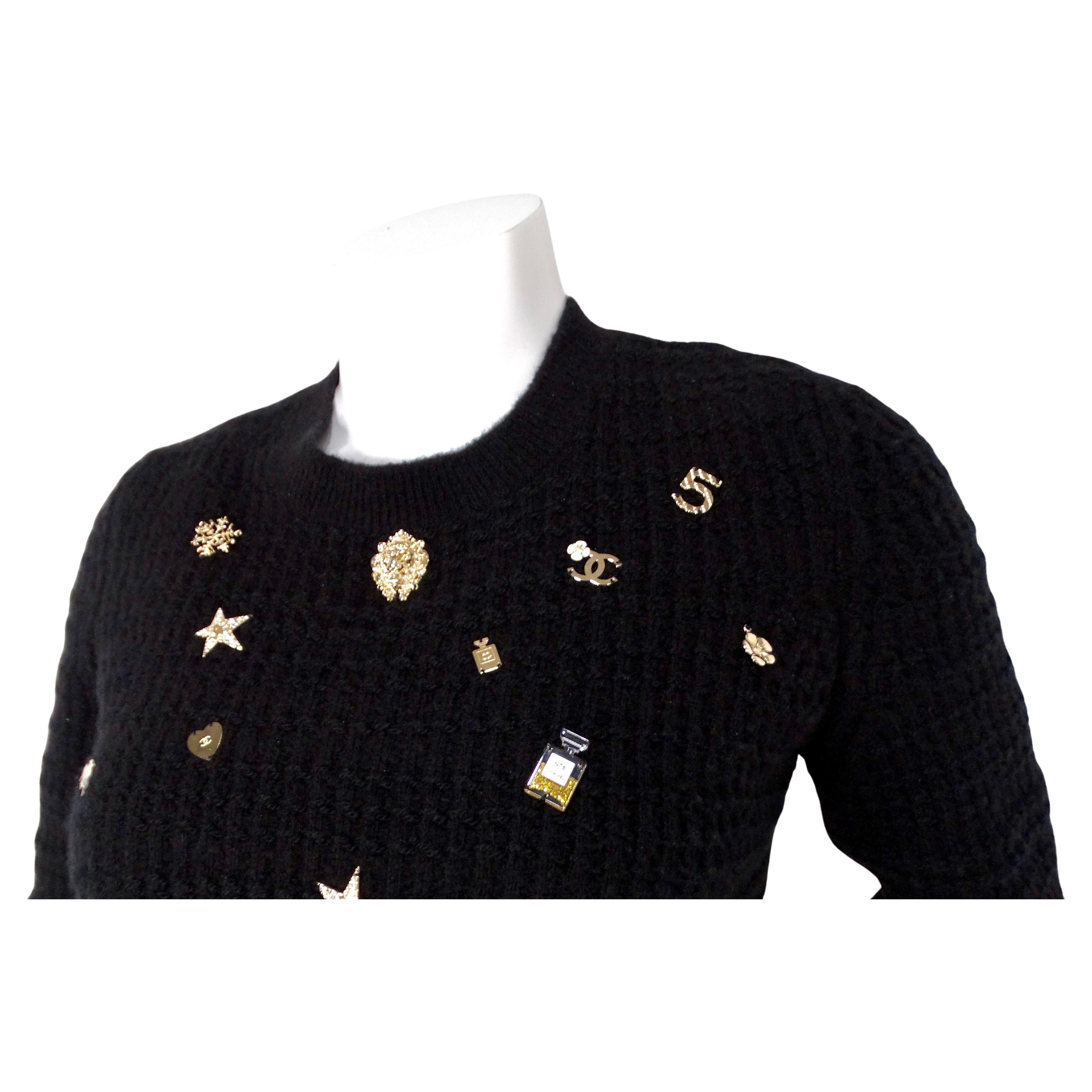 Le pull noir Coco Neige Lucky Charms en cachemire et laine mélangés de Chanel de 2018 est une pièce exquise qui allie harmonieusement luxe et design ludique. Confectionné dans un somptueux mélange de cachemire, de laine et de soie, ce pull-over de