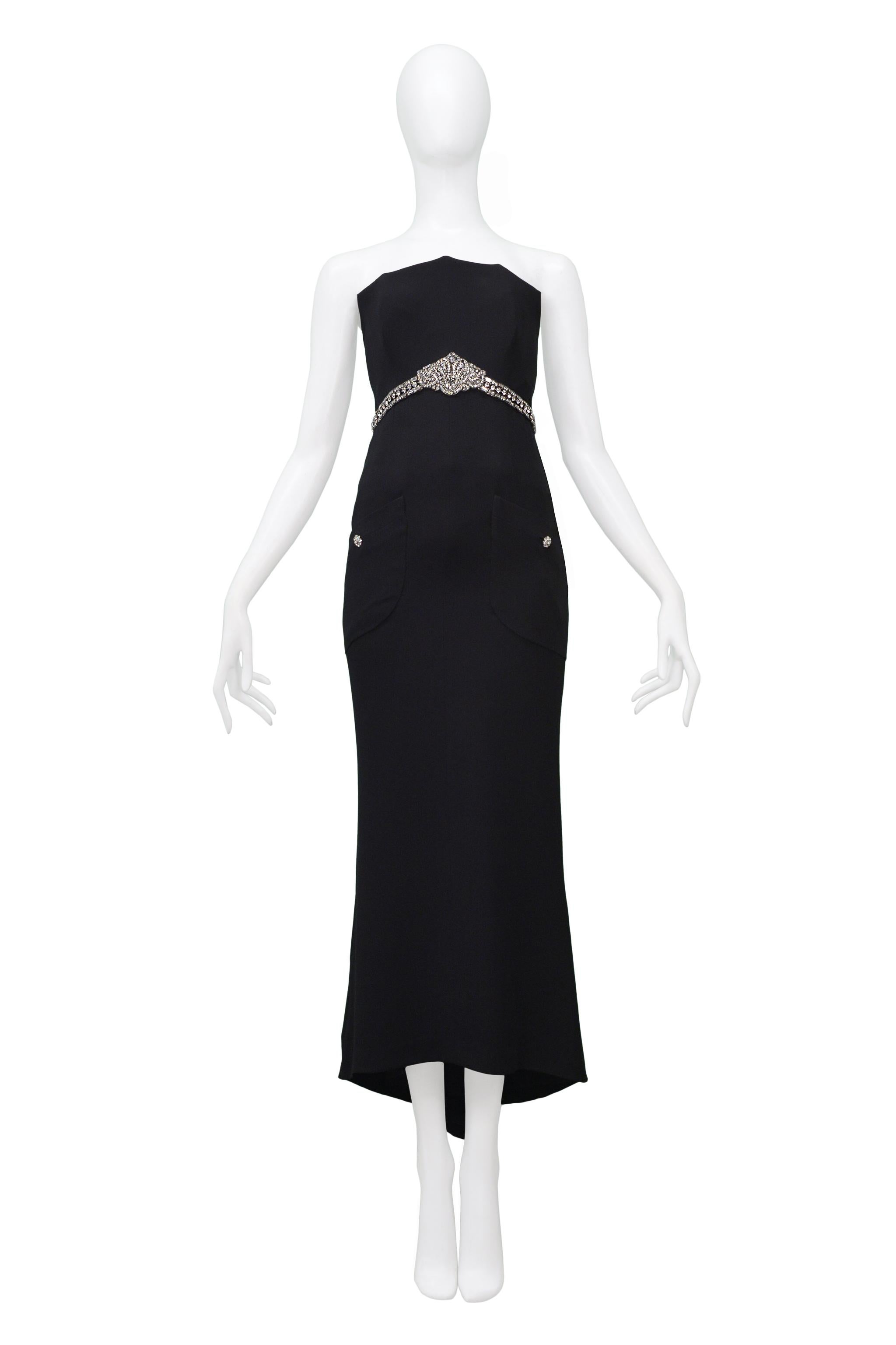 Resurrection Vintage is excited to offer a vintage Chanel black staples evening gown, featuring a webbed bodice, interior corset, rhinestone-encrusted empire waistband, and floral buttons, hand-stitched front pockets, and center back zipper.