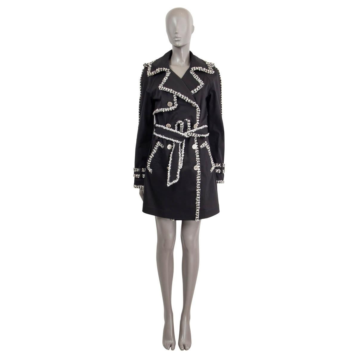 100% authentic Chanel double breasted trench coat in black cotton (95%) and polyurethane (5%) embellished with signature braided bouclé and sequin trim in white and light grey. The design features two front pockets, a waist belt, epaulette on the
