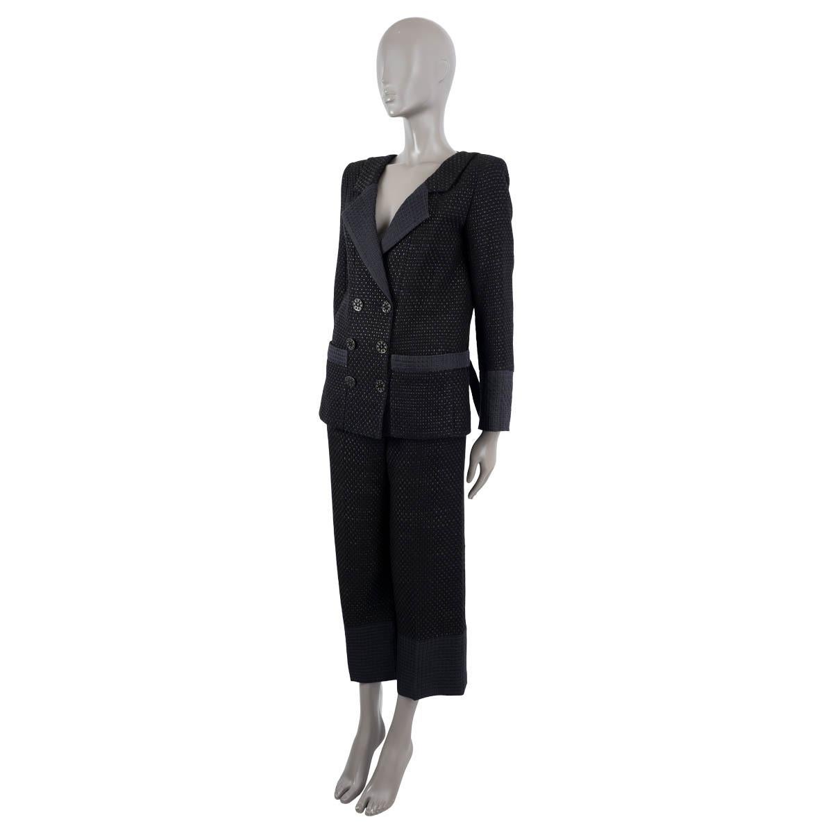 100% authentic Chanel double-breated pant suit in black tweed and midnight blue cotton (70%) and polyester (30%). The design features six CC logo and Camellia embellished black buttons and three on each cuff. Classic notch lapel and two patch