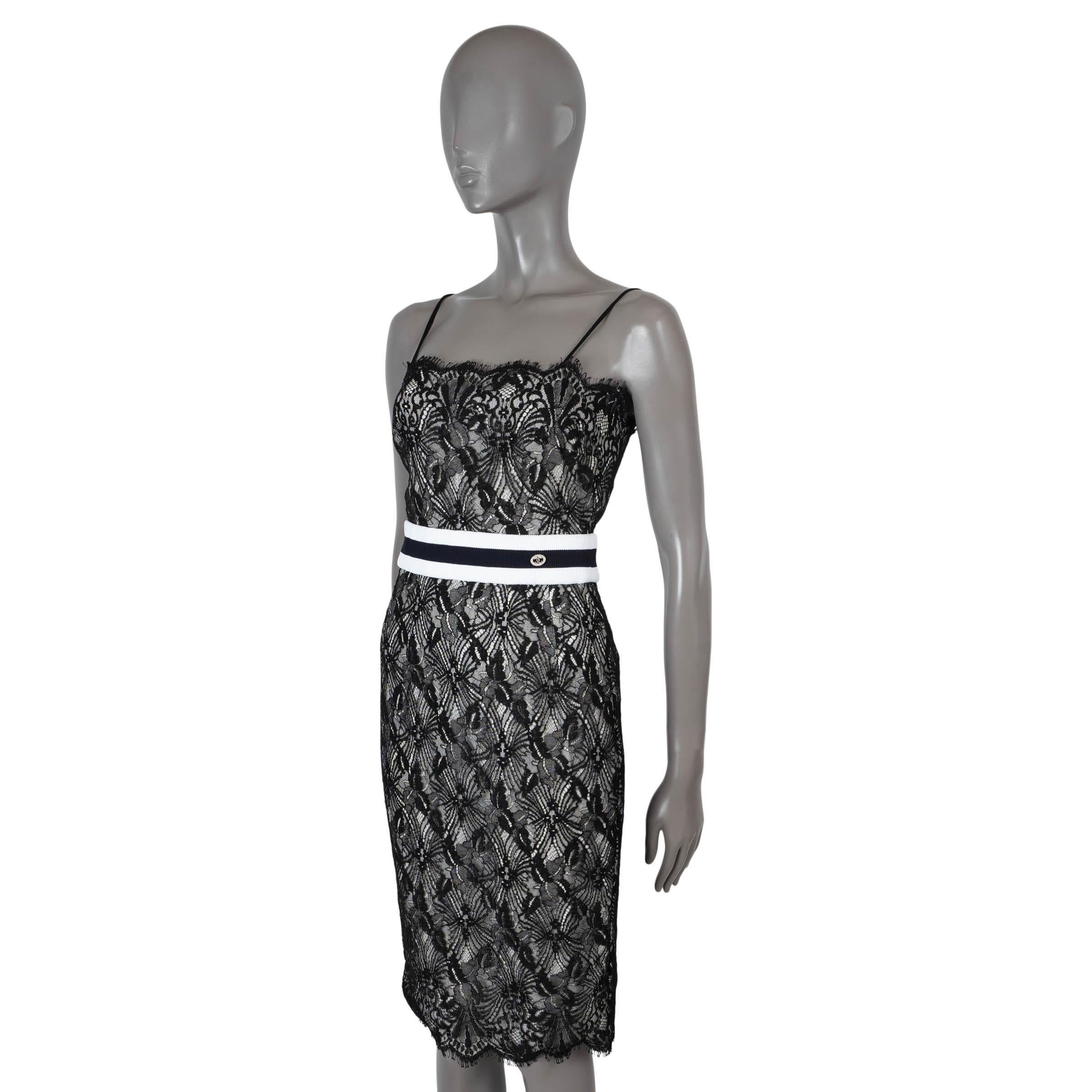 100% authentic Chanel sleeveless cocktail dress in black lace cotton (60%), rayon (25%) and nylon (15%). Features a tailored, knee-length silhouette, spaghetti straps, fringed edges and a rib-knit waist band with CC buttons. Opens with a concealed