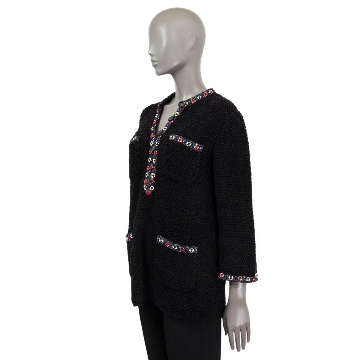 This 100% authentic Chanel chunky bouclé knit tunic in black is crafted from a luxurious blend of cotton (77%), polyamide (19%), and polyester (4%). It features four patch pockets on the front and is adorned with a navy trim embellished with