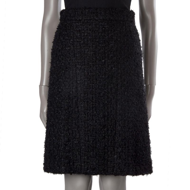 100% authentic Chanel high-waisted boucle skirt in black acrylic (24%), cotton (23%), nylon (22%), rayon (15%), mohair (14%), and polyester (2%). Closes with two hooks and invisible zipper in the back. Lined in black silk (100%). Has been worn and