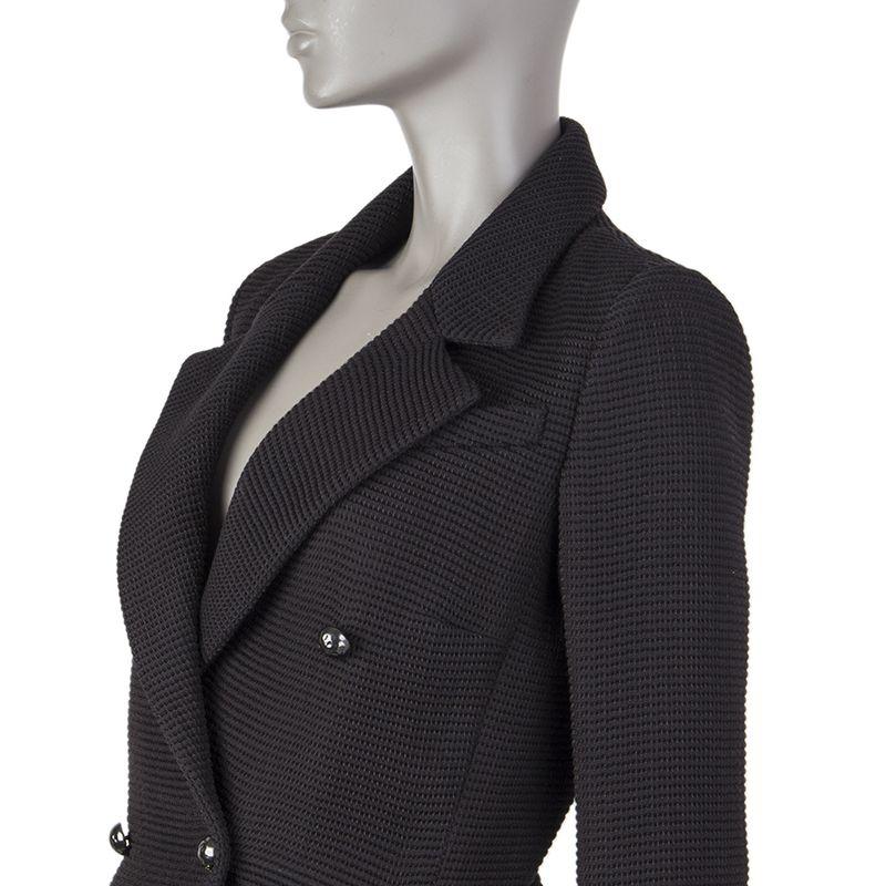 Chanel waffle-weave double.breasted jacket in black cotton (81%) and nylon (19%). With notch collar, chest pocket, curved slits on the sides, and pewter pearl chain on the back of the waist. Closes with CC dented half-ball buttons on the front.