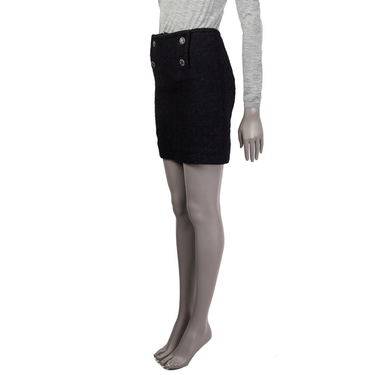 Chanel quilted-tweed double-breasted pencil skirt in black cotton (44%), nylon (40%), rayon (12%), and polyester (4%). With slit on the back. Closes with concealed zipper, hooks and snaps on the front, as well as CC crest buttons in black and silver