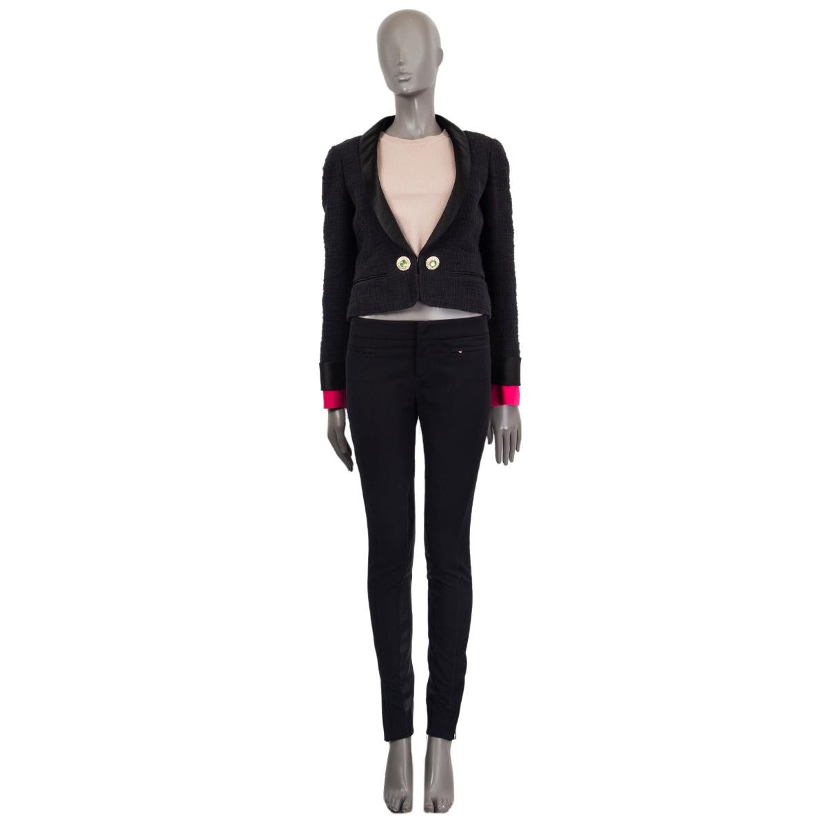 Chanel tweed dinner jacket in black cotton (100%) with satin shawl collar and cuffs. Detachable hot pink silk cuffs, rhinestone and faux pearl embellished buttons, slit pockets (still sewn shut. Closes with a hidden hook on the front. Lined in silk