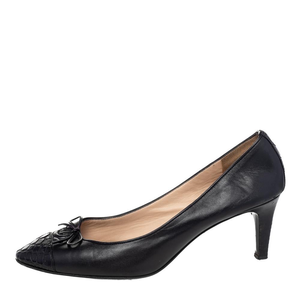 Fashion-forward and chic, these intricately designed pumps are made of leather. Chanel is known for its classy yet simple designs. This pair of black pumps brings to your effortless style with croc-embossed cap toes, CC logo and bow details on the