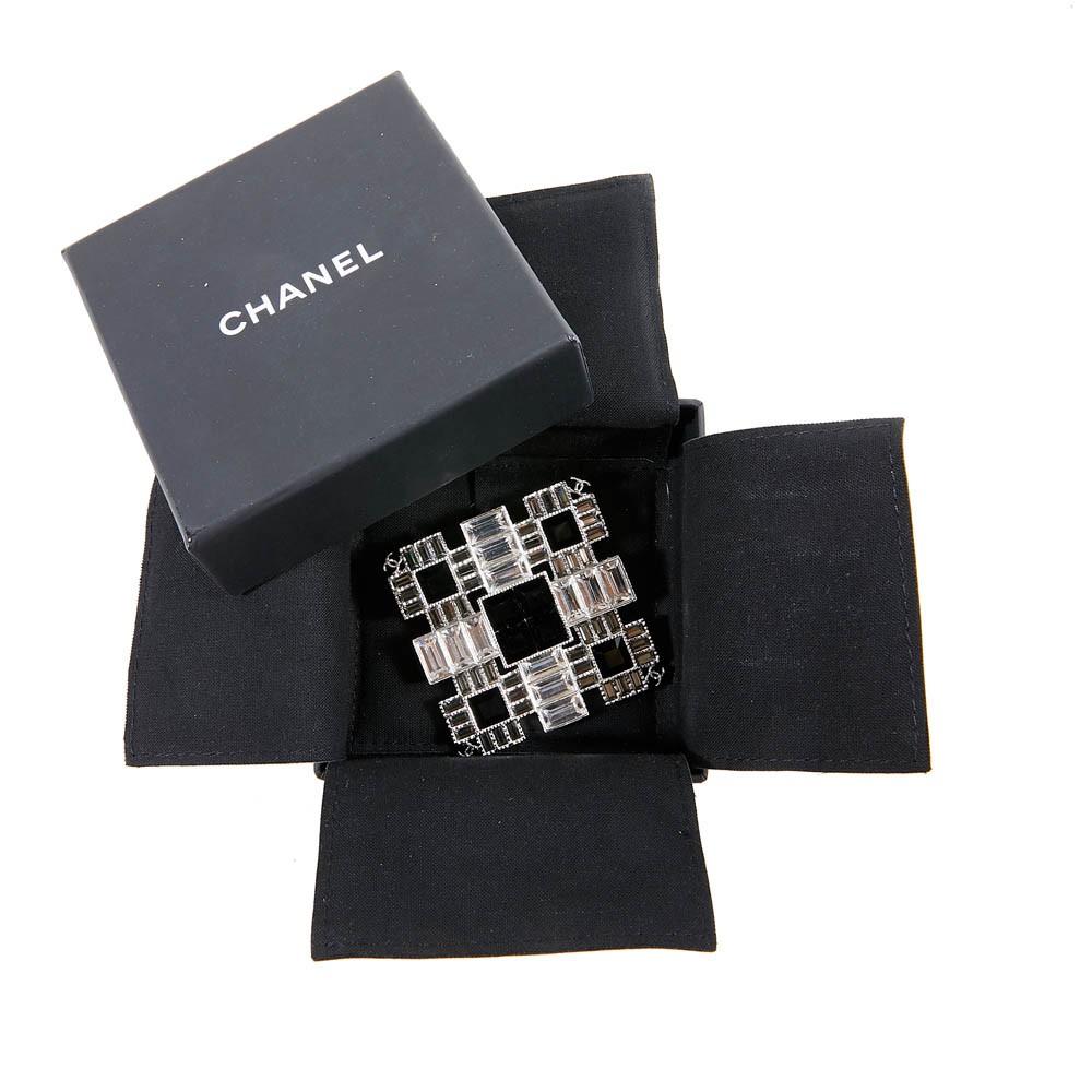 Made in France in 2015, this brooch has a contemporary design combination of gunmetal silver-plated metal, delicate black crystal and the brand's iconic signature interlocking CC logo. Never worn, in its original box. measures: 5x5 cm. 