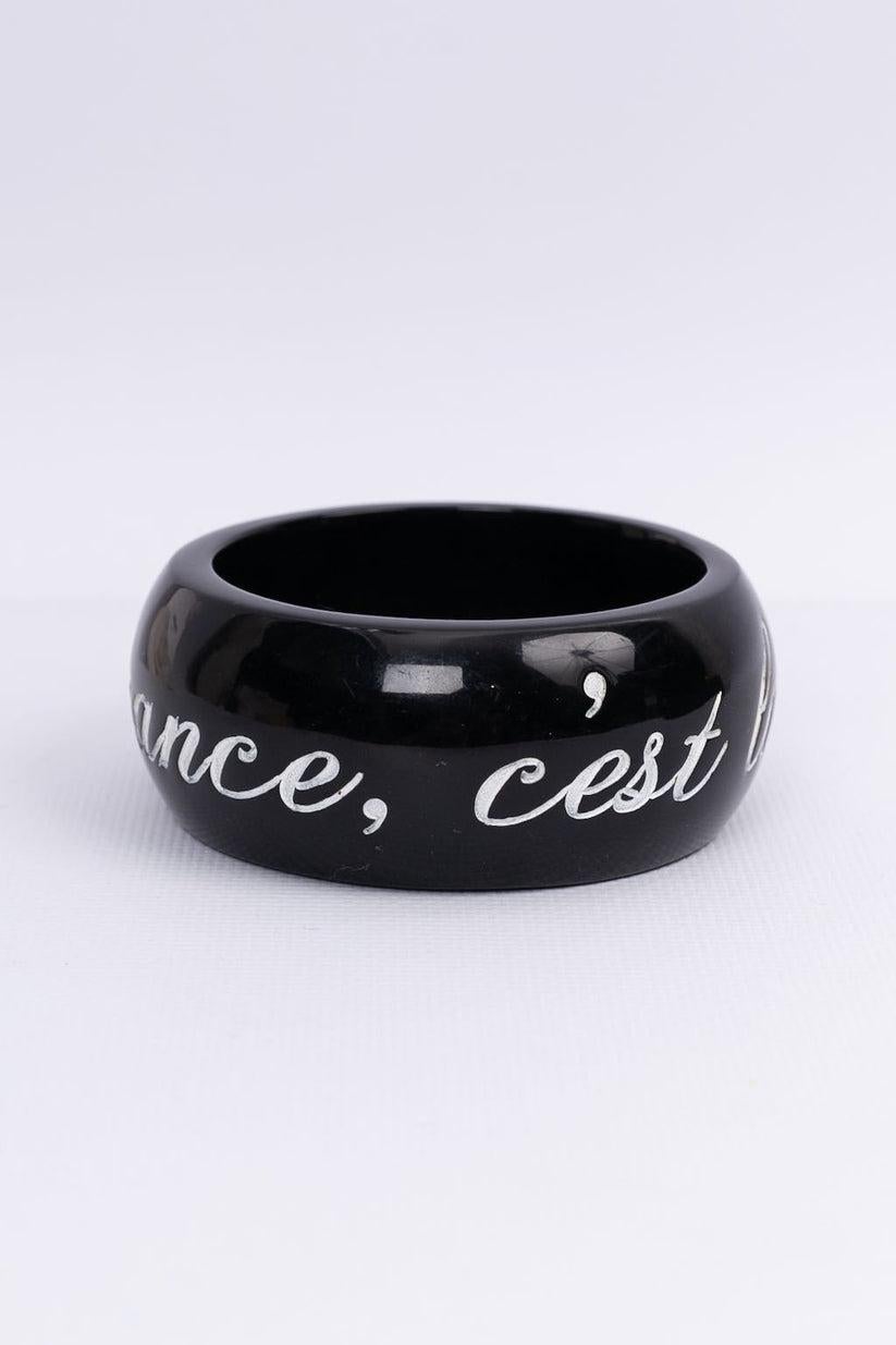 Chanel- (Made in France) Black cuff bracelet decorated with a sentence reading 