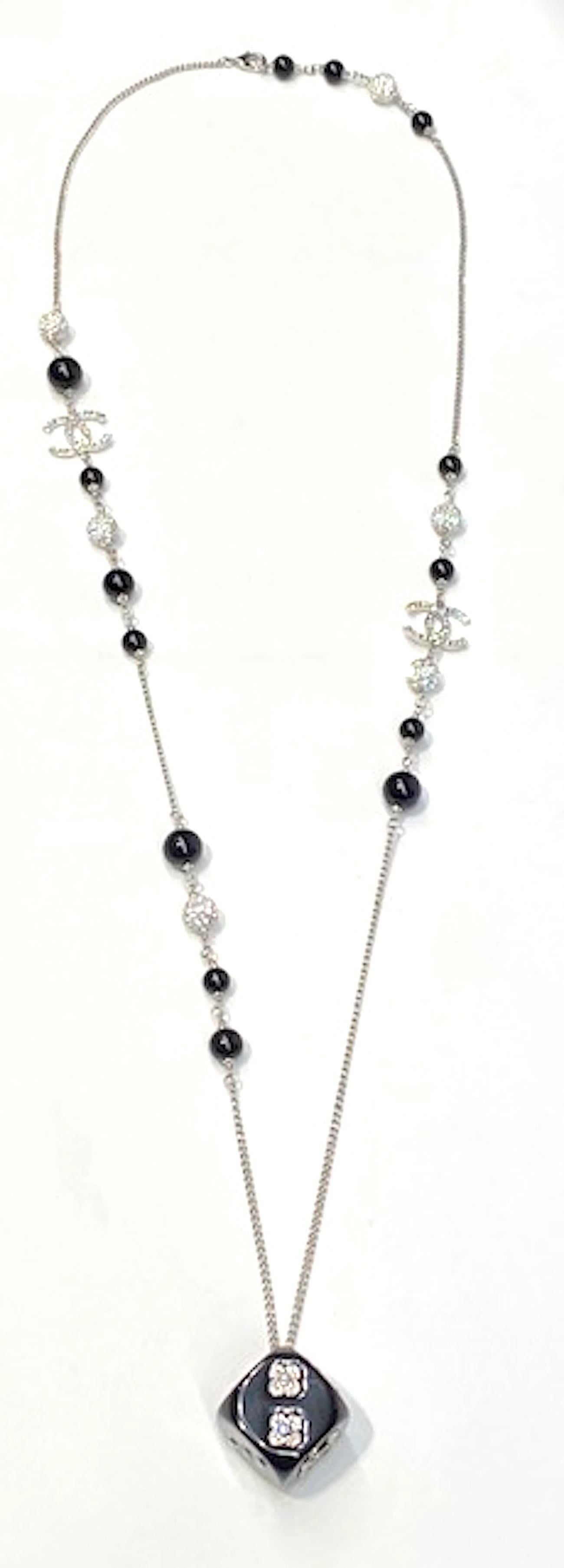A Chanel unique and fun dice pendant necklace from the 2018 Autumn Collection. The rhodium curb link chain is strung intermittently with 8 and 10 mm black glass beads and 9 mm rhinestone set beach. Additionally, there are two rhinestone set Chanel