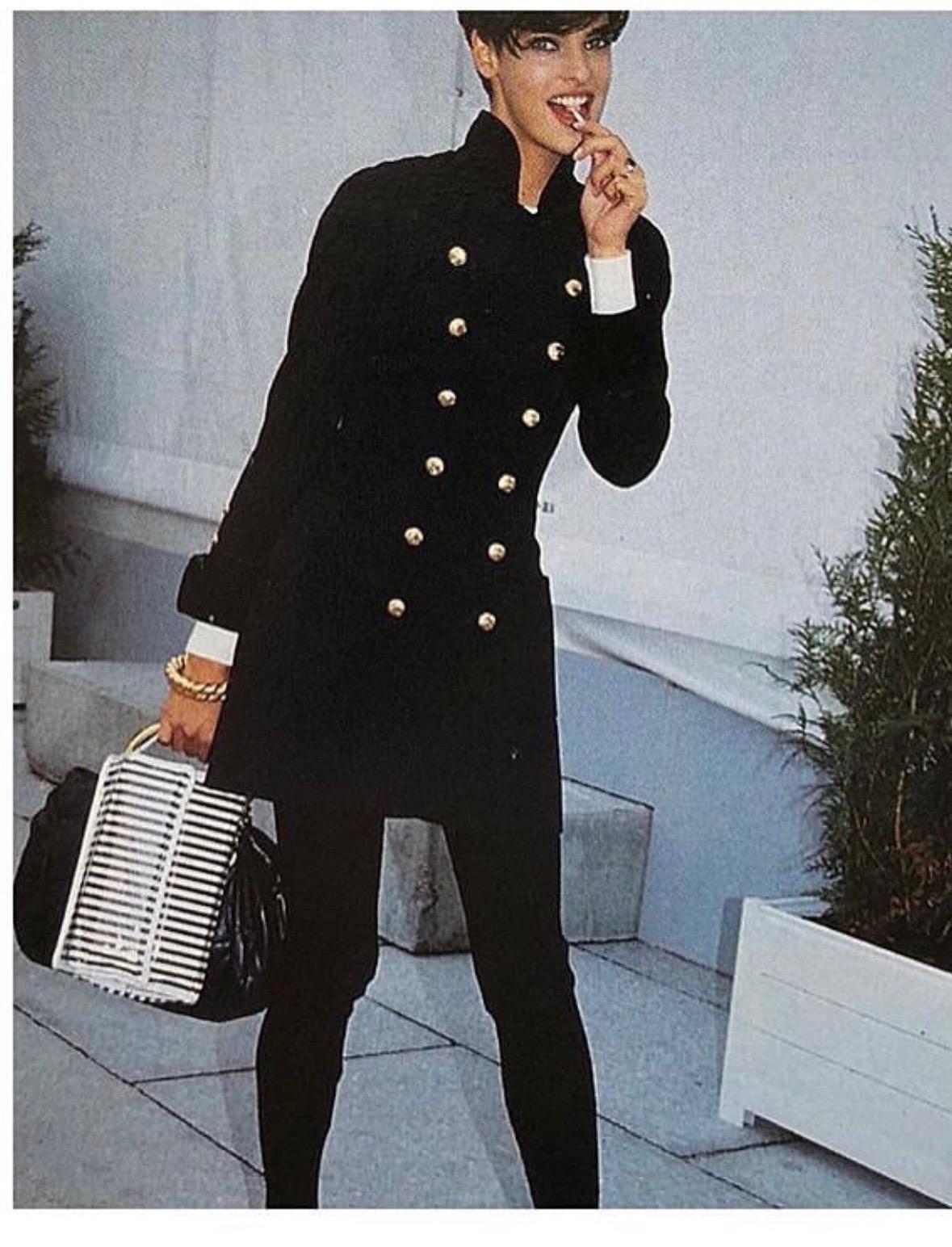 The Chanel Black Double Breasted Wool & Velvet Jacket Dress Documented, as seen on Linda Evangelista, from the circa 1980s epitomizes timeless elegance and sophisticated craftsmanship. Crafted from rich black wool with sumptuous velvet accents, this