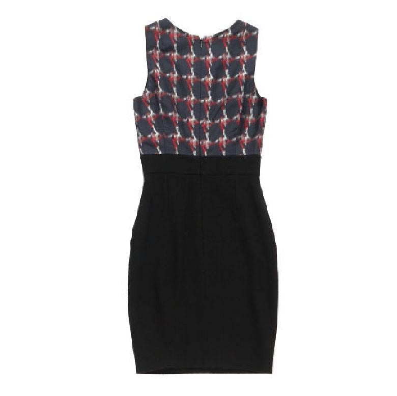 Vestido negro Chanel la parte de arriba es de seda y la de abajo de lana. Se cierra con una cremallera en la espalda. Dos bolsillos de parche en la parte delantera y una pequeña sigla con una cabeza de león cosida en la cintura. Una pequeña toma de