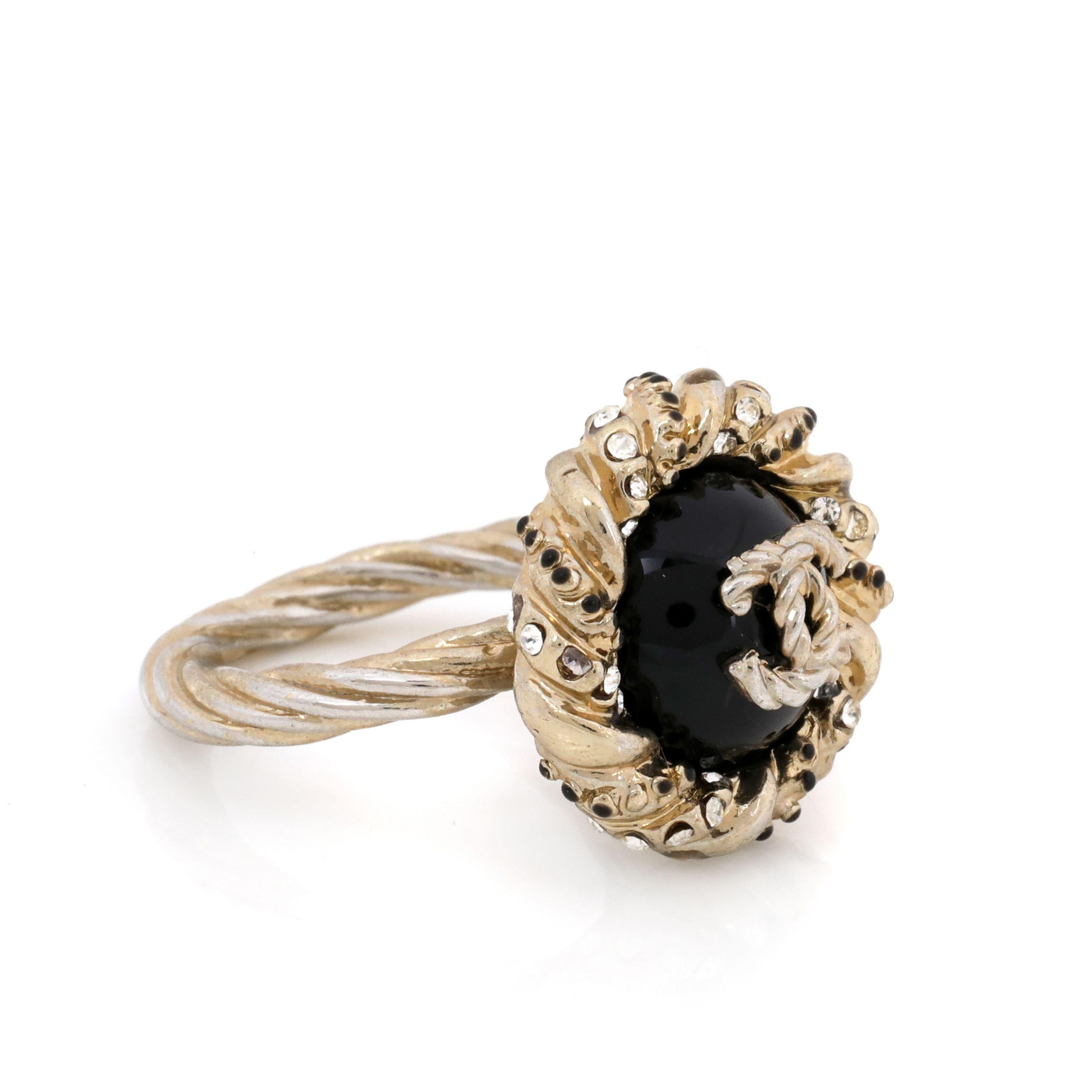 This authentic. Chanel Black Enamel Ring with CC Center is in excellent condition.  Black enamel, crystal embellishments with a worn gold finish.  Size 7.  Pouch or box included. 

PBF 14022
