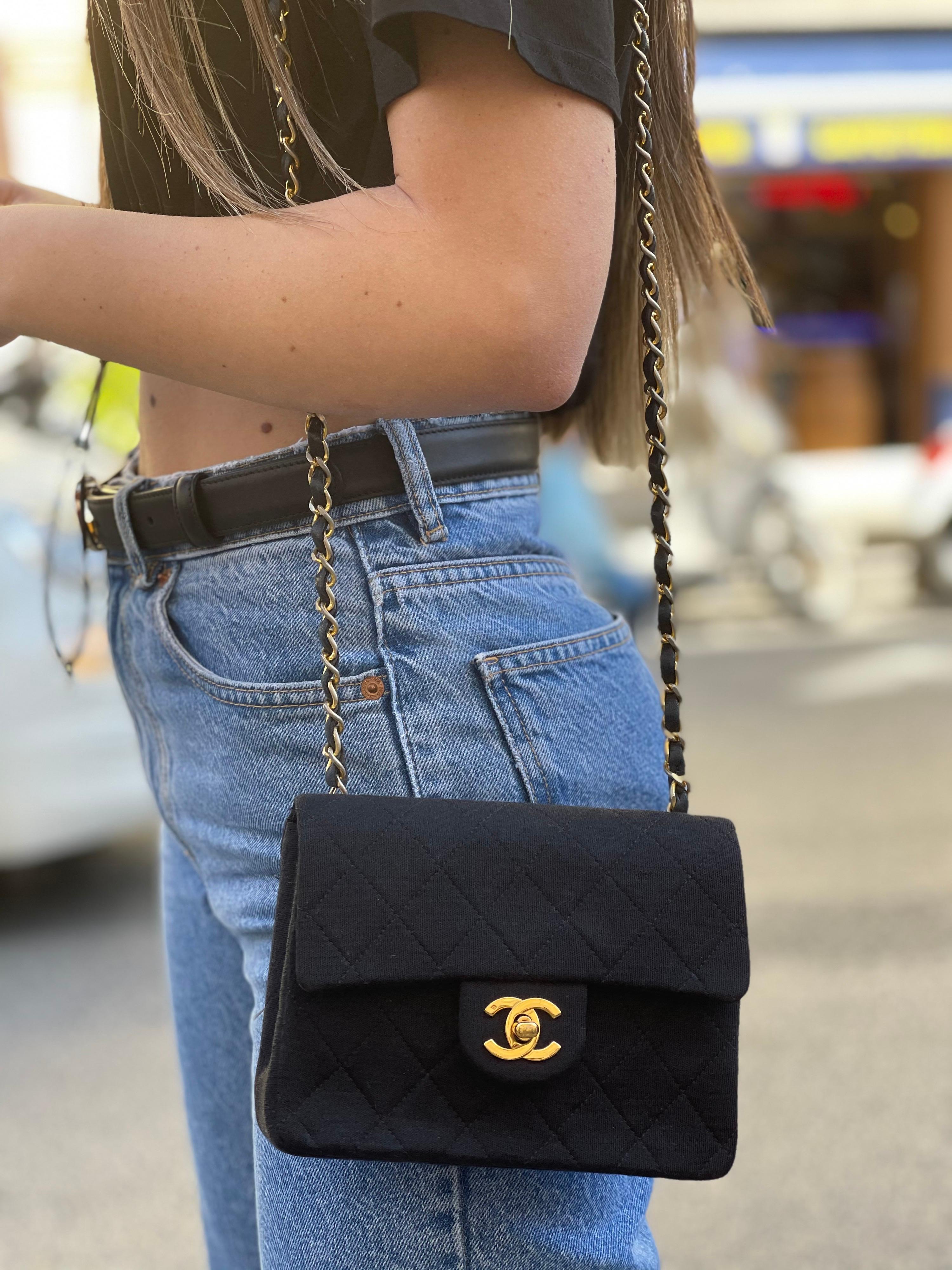 Chanel Mini Flap made of black fabric with golden hardware. Closure with CC hook, internally not very large. Equipped with a leather and chain shoulder strap. It seems in perfect conditions.