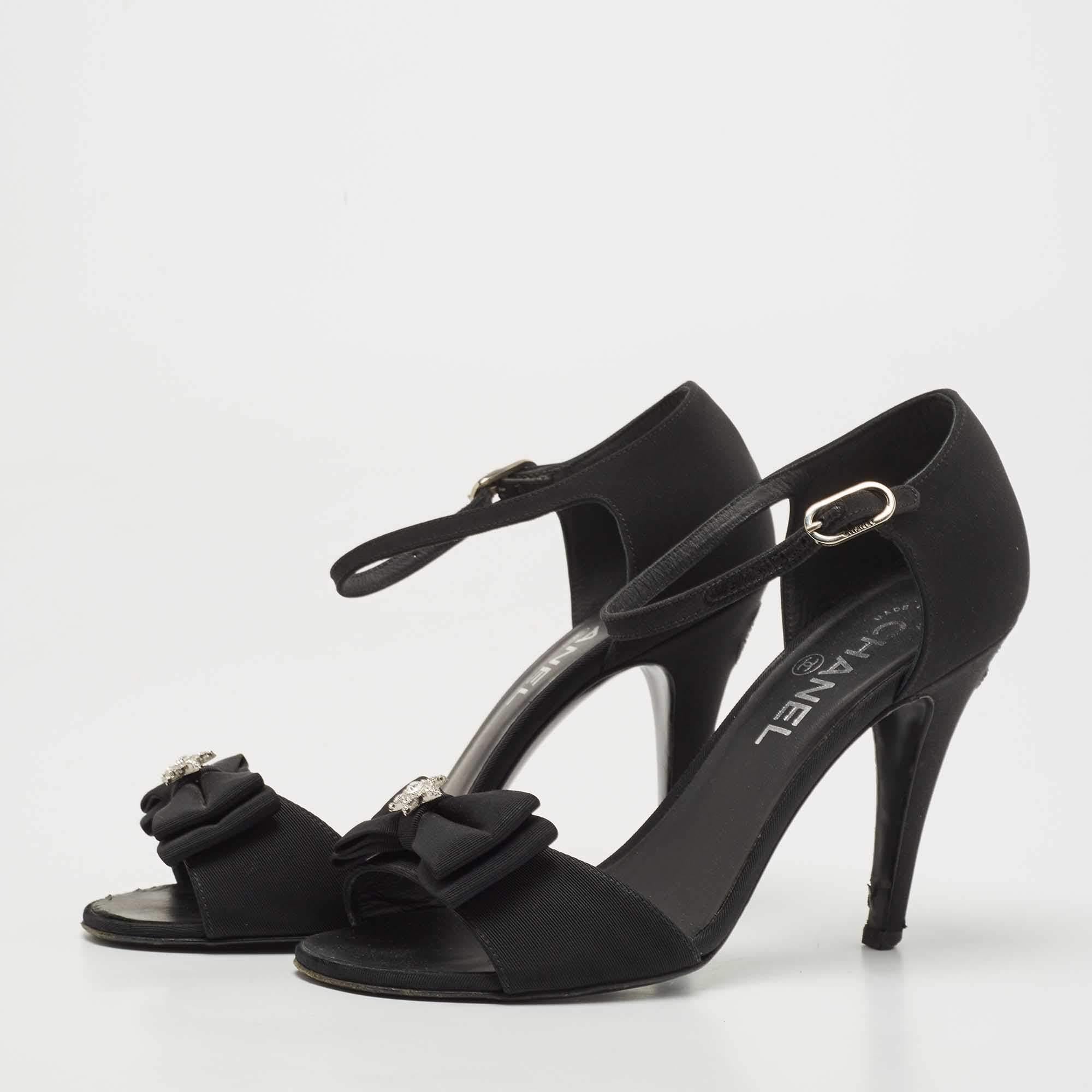 This classy pair of sandals from Chanel looks even better on the feet. The shoes have a fabric exterior added with bows, simple buckle closures, and open toes. They are lifted on 10 cm heels.

