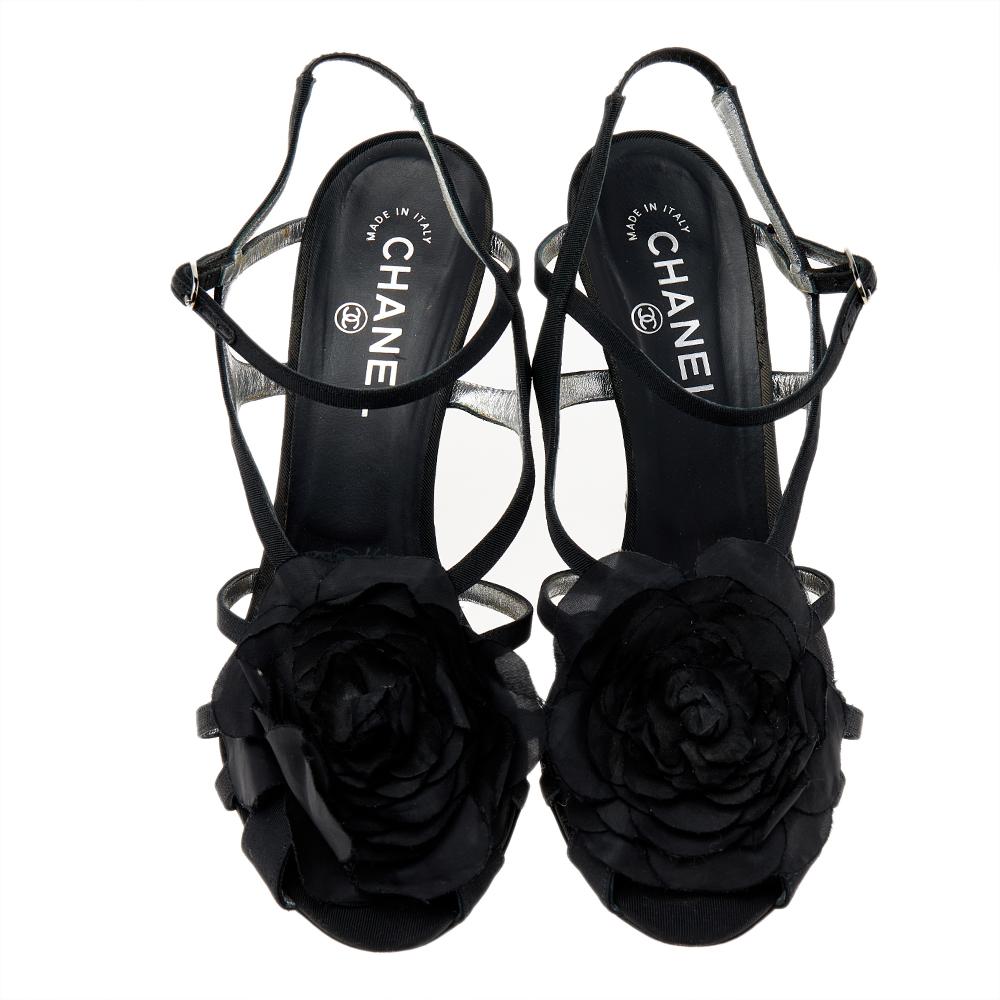 These lovely Chanel sandals will bring you the right amount of style and glamor. Crafted from black fabric, they feature the signature Camellia flower on the strappy vamps, ankle straps with buckles, silver-tone CC logo on the high heels. They are