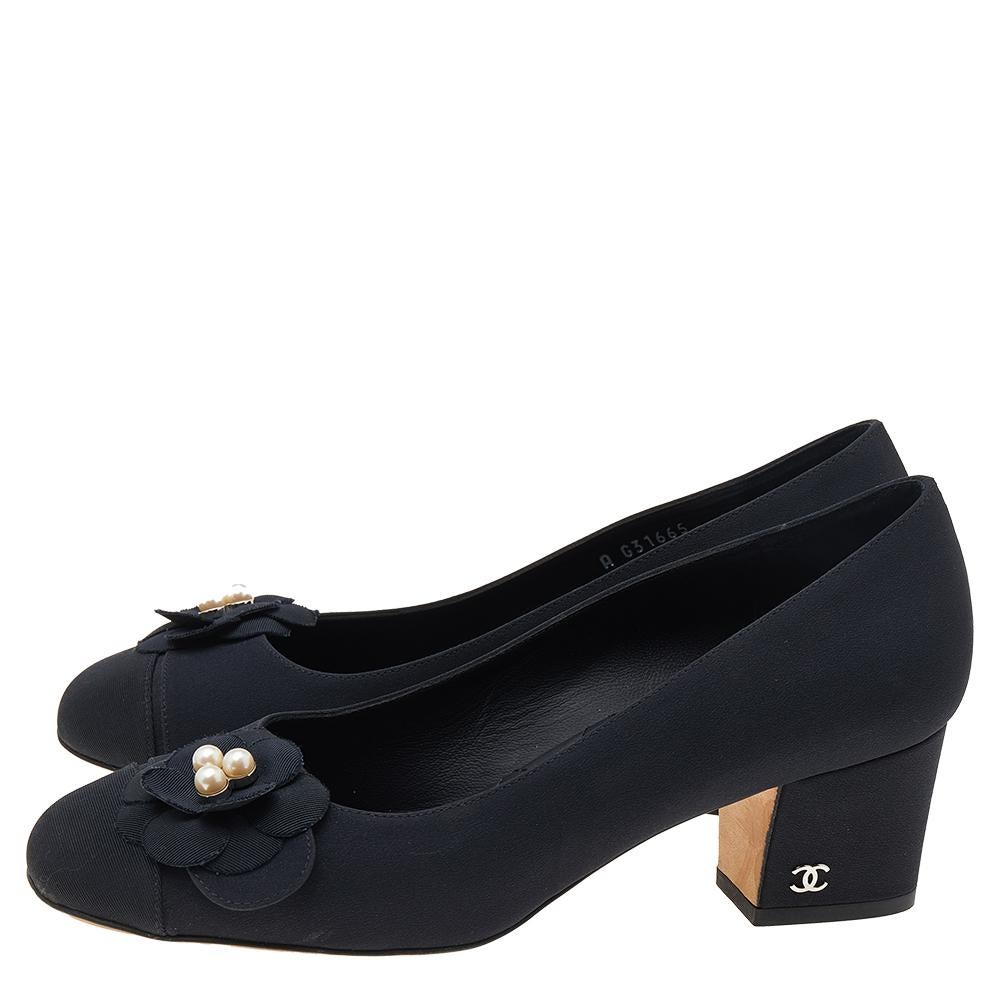 This pair of pumps from the house of Chanel is just what you need to take your style quotient a few notches higher. Made from smooth black fabric, their versatile design features round toes with vamps embellished with the signature Camellia flower.