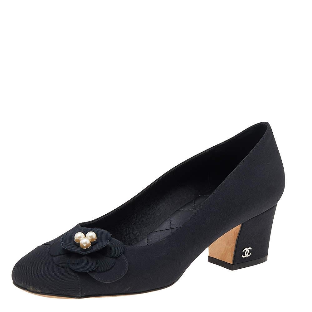 This pair of pumps from the house of Chanel is just what you need to take your style quotient a few notches higher. Made from smooth black fabric, their versatile design features round toes with vamps embellished with the signature Camellia flower.
