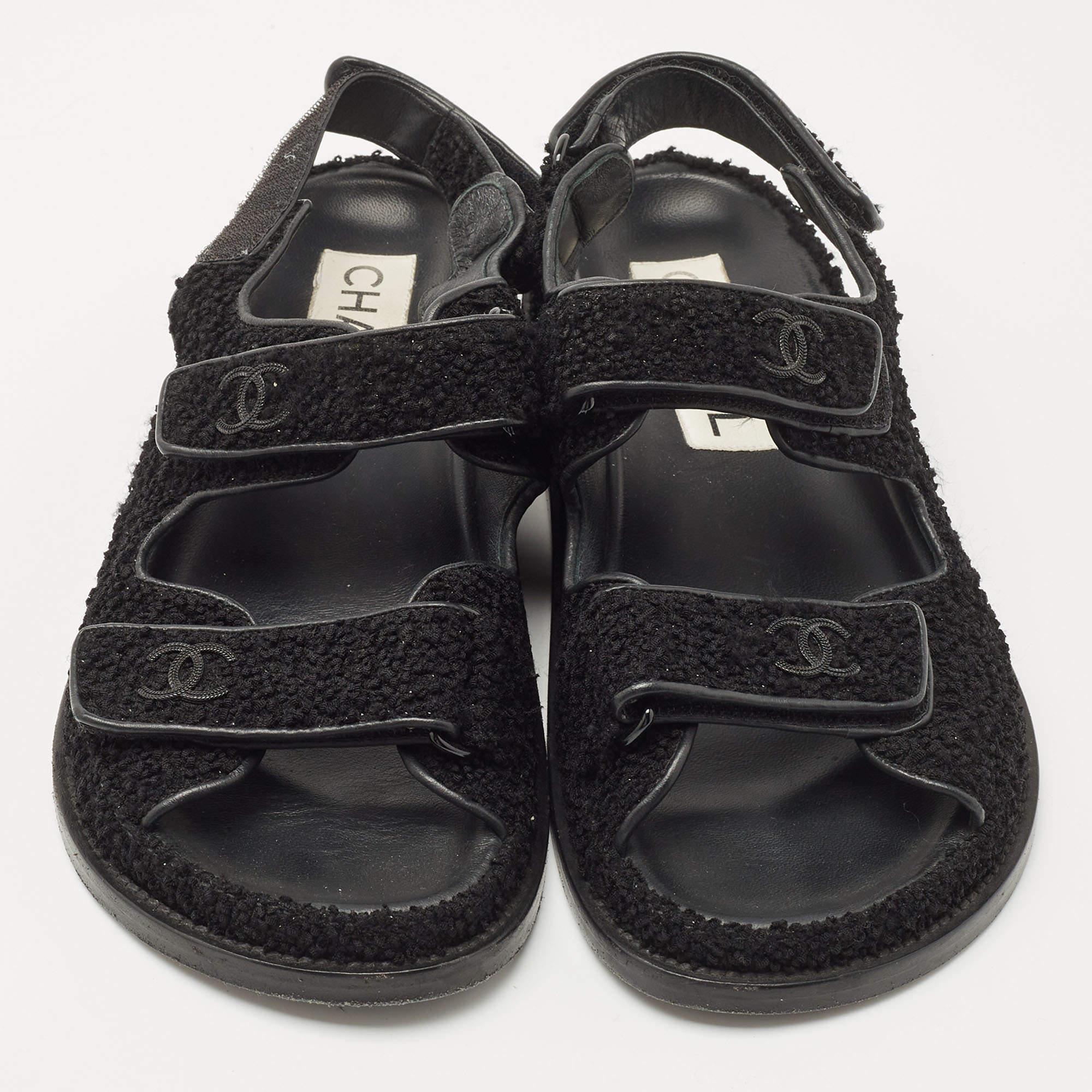 A perfect blend of comfort and style, these black sandals are just what you need for a day out. Elevate your outfit with these quilted fabric flats. They come from the house of Chanel and feature velcro straps and the CC logo.


