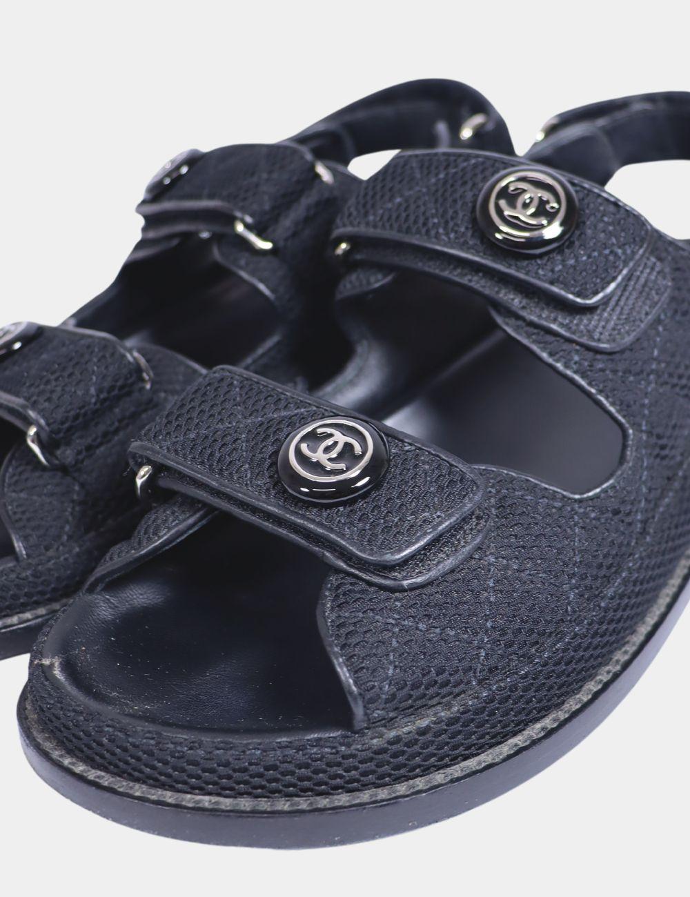 Chanel Black Fabric Interlocking CC Dad Sandals, features a round-toe, and a silver cc logo.
Material: Fabric

Size: EU 38
Overall Condition: Good
Interior Condition: Scratches from the front
Exterior Condition: Signs of wear on the soles
*Dust bag