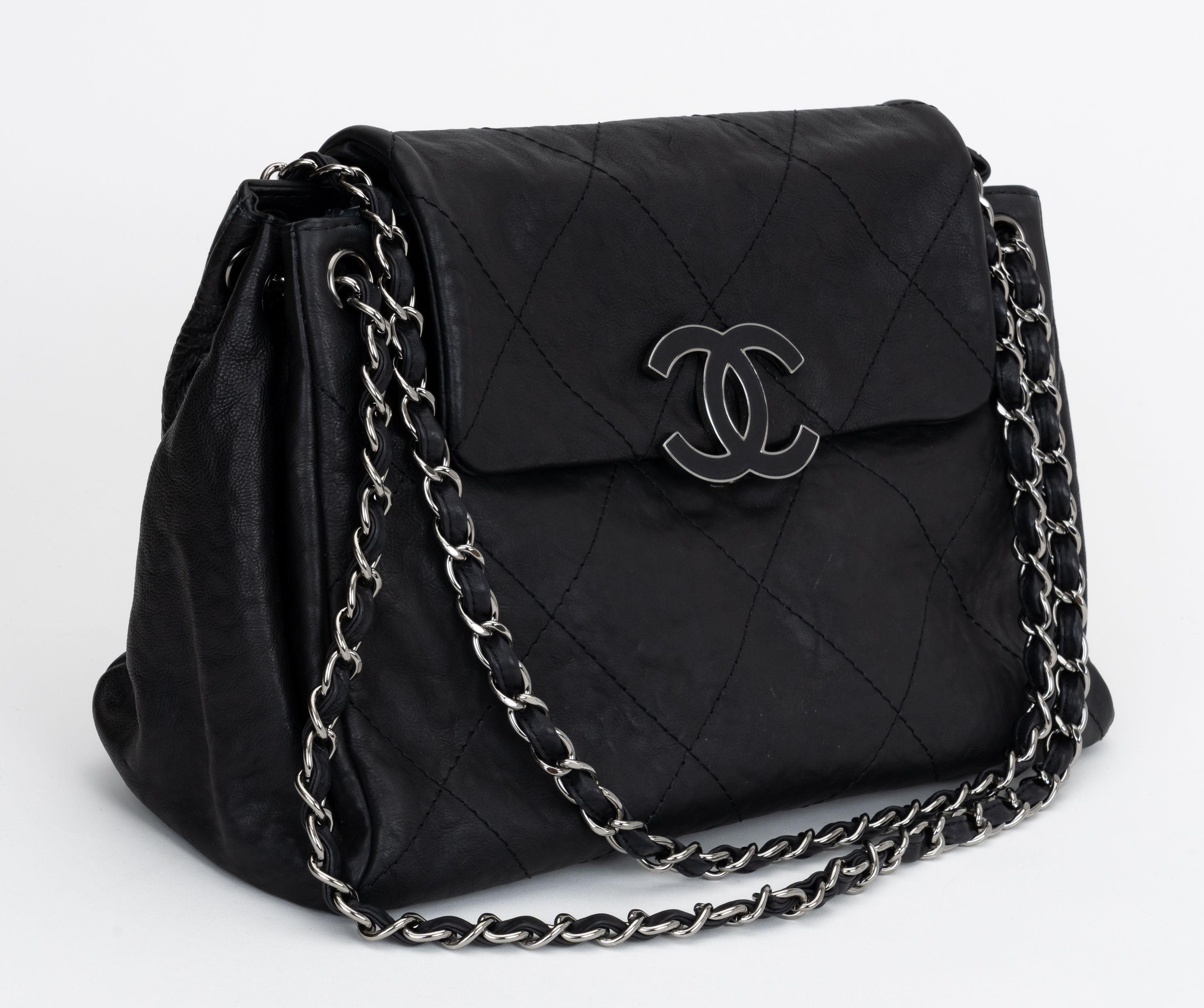 Chanel large black flat quilted shoulder bag with silver tone hardware.  Interior zipped compartment and key strap. Shoulder drop 11