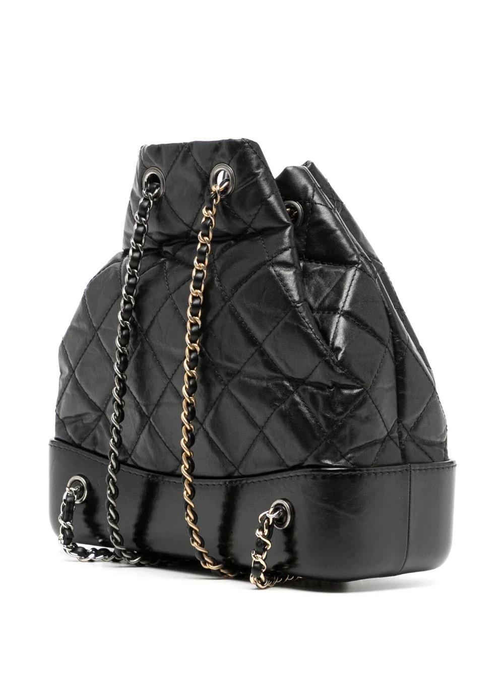 The Chanel Gabrielle Backpack is from a line designed by Karl Lagerfeld for the Spring/Summer 2017 Ready-to-wear show. It features aged black quilted leather, a sturdy base of smooth black leather, the iconic CC logo, and woven chain leather straps.