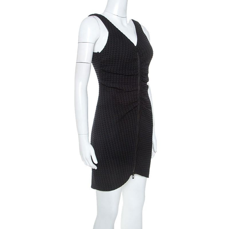 Masterful tailoring and simple style characterize this dress from the house of Chanel. It features geometric patterns, a full front zipper that releases ruched pleats and a scoop back. The dress in black has a seamless finish and a captivating