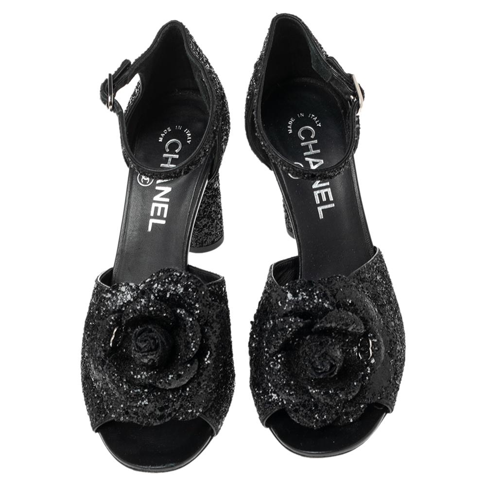 These sandals are crafted from glitter for your comfort. Flaunt this fabulous pair from Chanel as step out in style. These come in a classic shade of black with details of camellias and the CC logo on the vamps. The sandals are complete with ankle