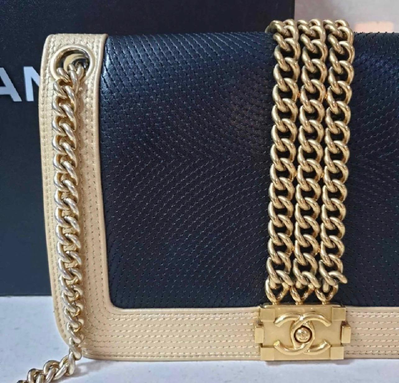  Chanel Le Boy Bag

This stunning black and gold leather Le Boy bag is adorned with three gold tone chains and a gold tone Le Boy clasp. 
Made of soft lambkin with detailed stitching on the outside.
Lined in gold satin with a slip pocket