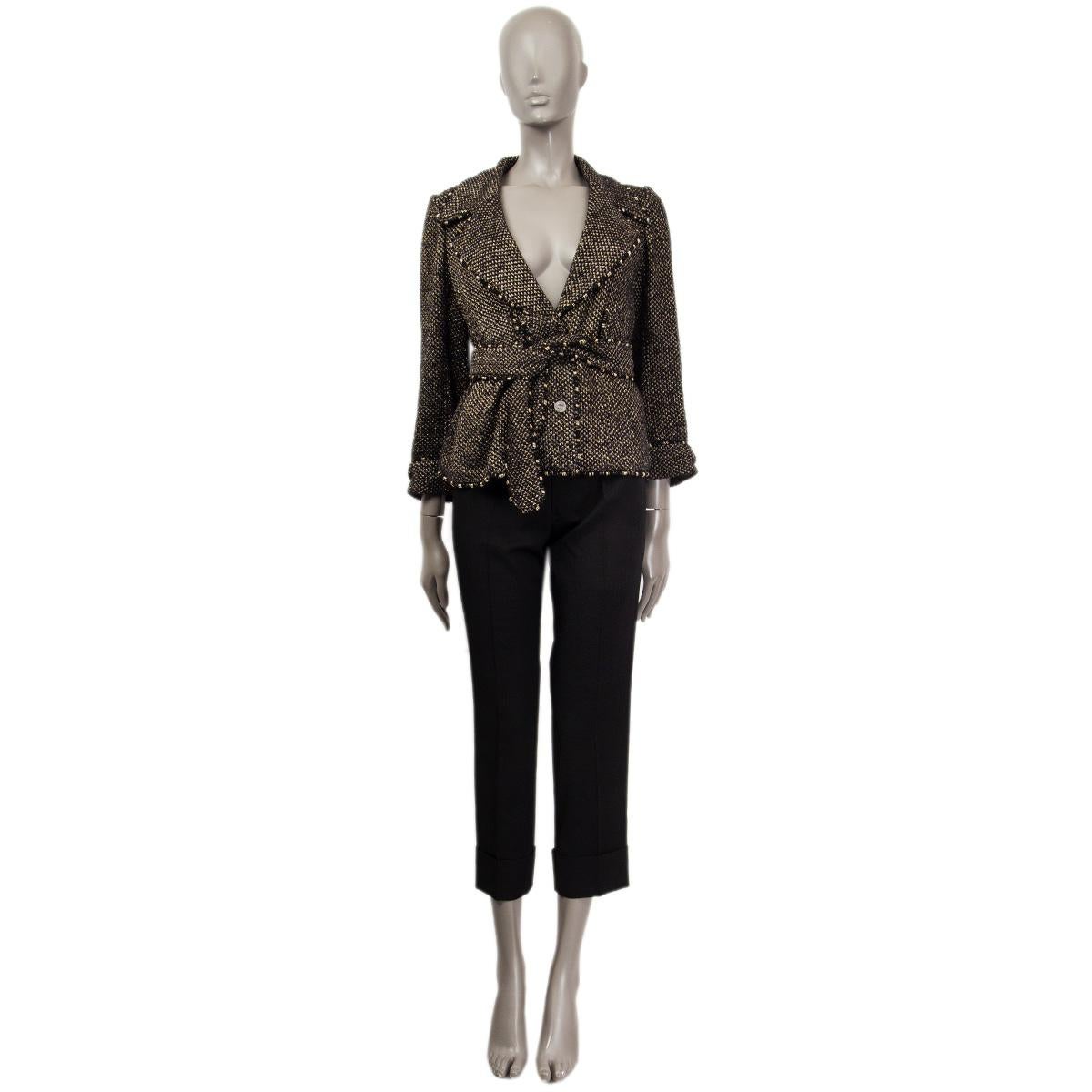 100% autentica giacca bouclé con cintura Chanel in cotone nero e oro (65%), viscosa (19%), poliammide (8%) e poliestere (8%). Ha un colletto con tacche e finiture in oro e argento impreziosite da anelli. Polsini risvoltati e abbottonati. Due tasche