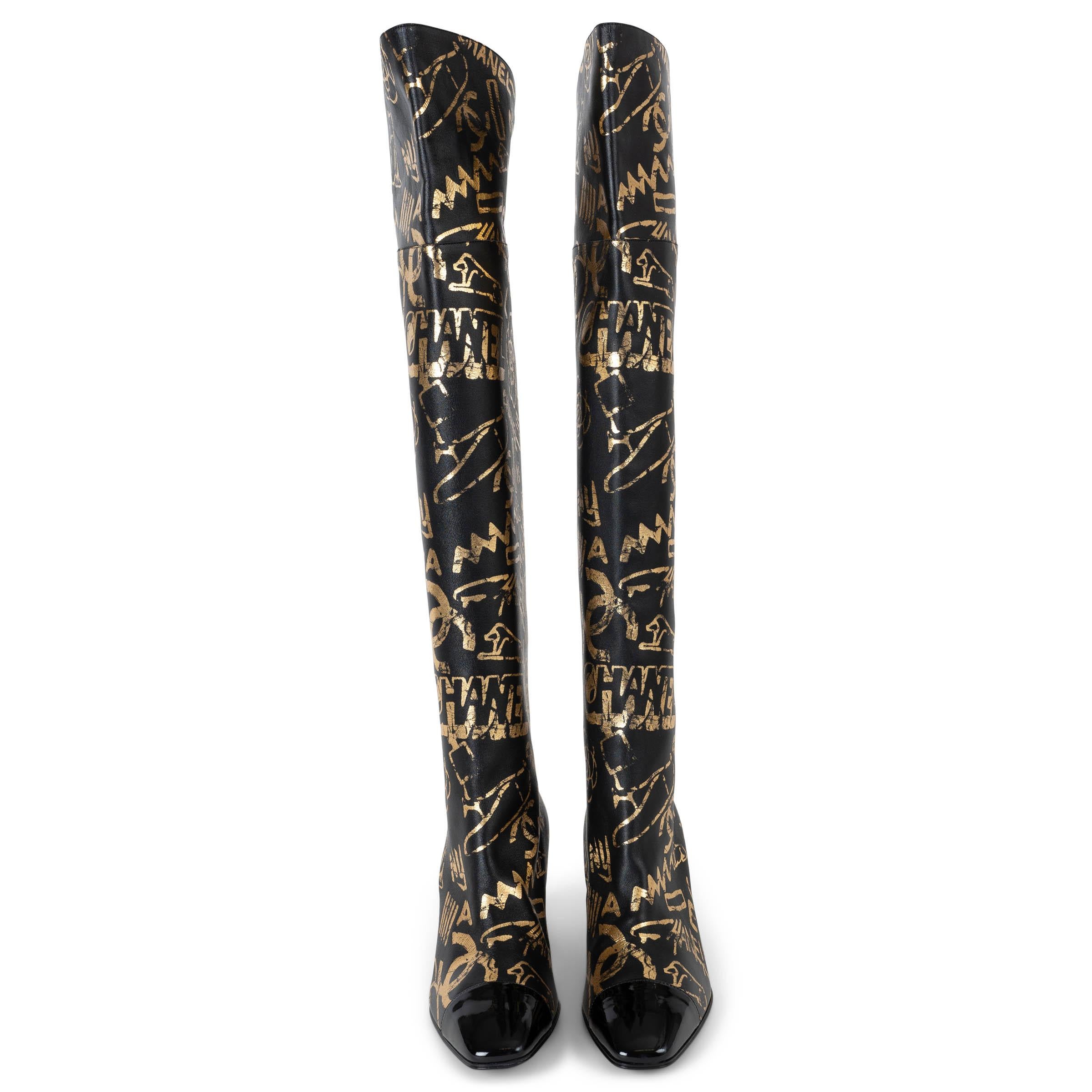 Ces bottes 100% authentiques de Chanel en cuir noir avec un imprimé Graffiti d'inspiration égyptienne en or métallique incarnent les codes audacieux de la maison. Conçues avec une tige au-dessus du genou, elles sont dotées de talons bloc sculptés,