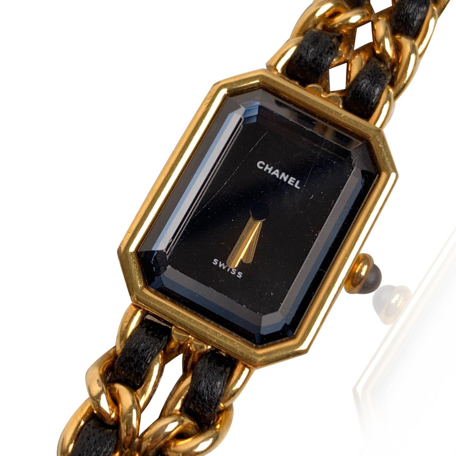 Beautiful Chanel 'Première' watch. This was the first wristwatch created by maison Chanel in 1987. The watch is made from gold-plated stainless steel and it features an iconic chain-link bracelet with interwoven leather. Octagonal case. Black dial.