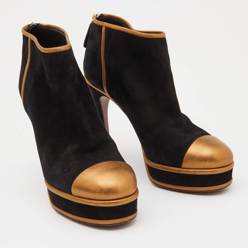 Give your outfit a chic update with this pair of Chanel ankle boots. The creation is sewn perfectly using leather & suede and added with contrasting panels, back zip closure, and 12 cm heels. Make a statement in these!

