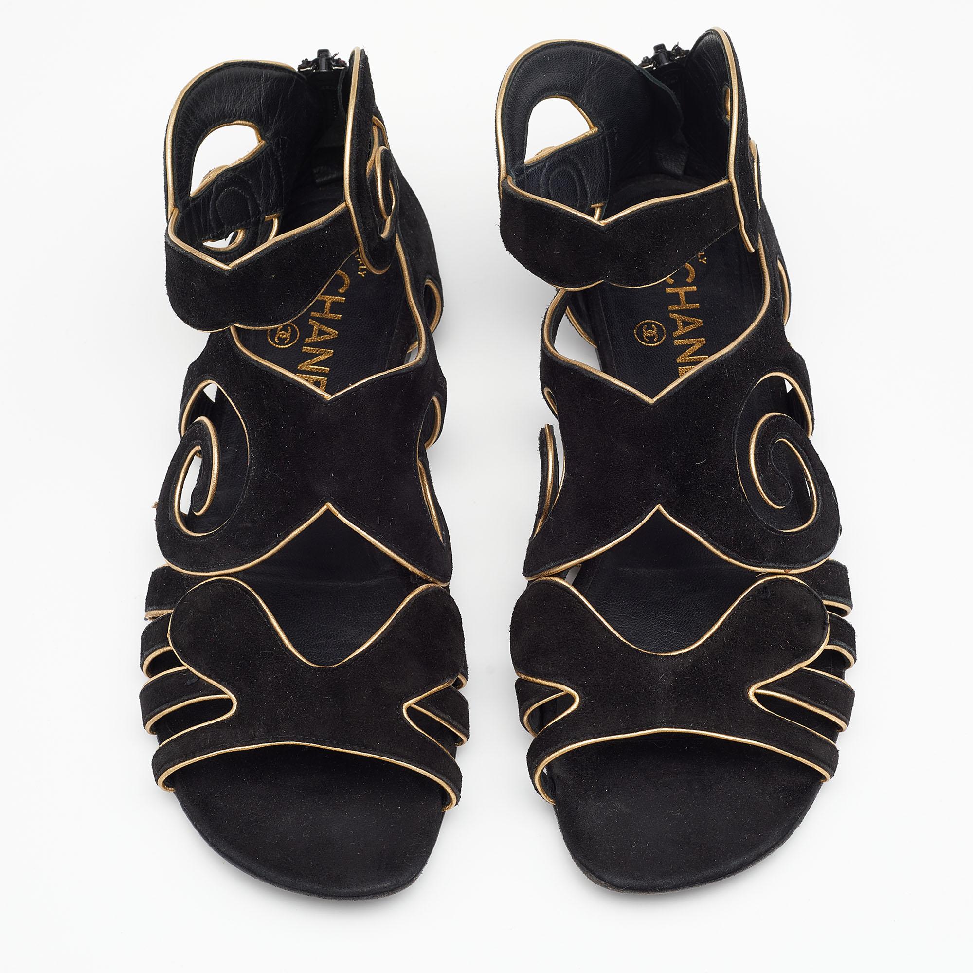 These gladiator flat sandals from the House of Chanel are all about class and elegance! They are made from black-gold suede on the exterior. They display black-tone hardware and a zipper closure. Flaunt your chic style with these Chanel sandals.

