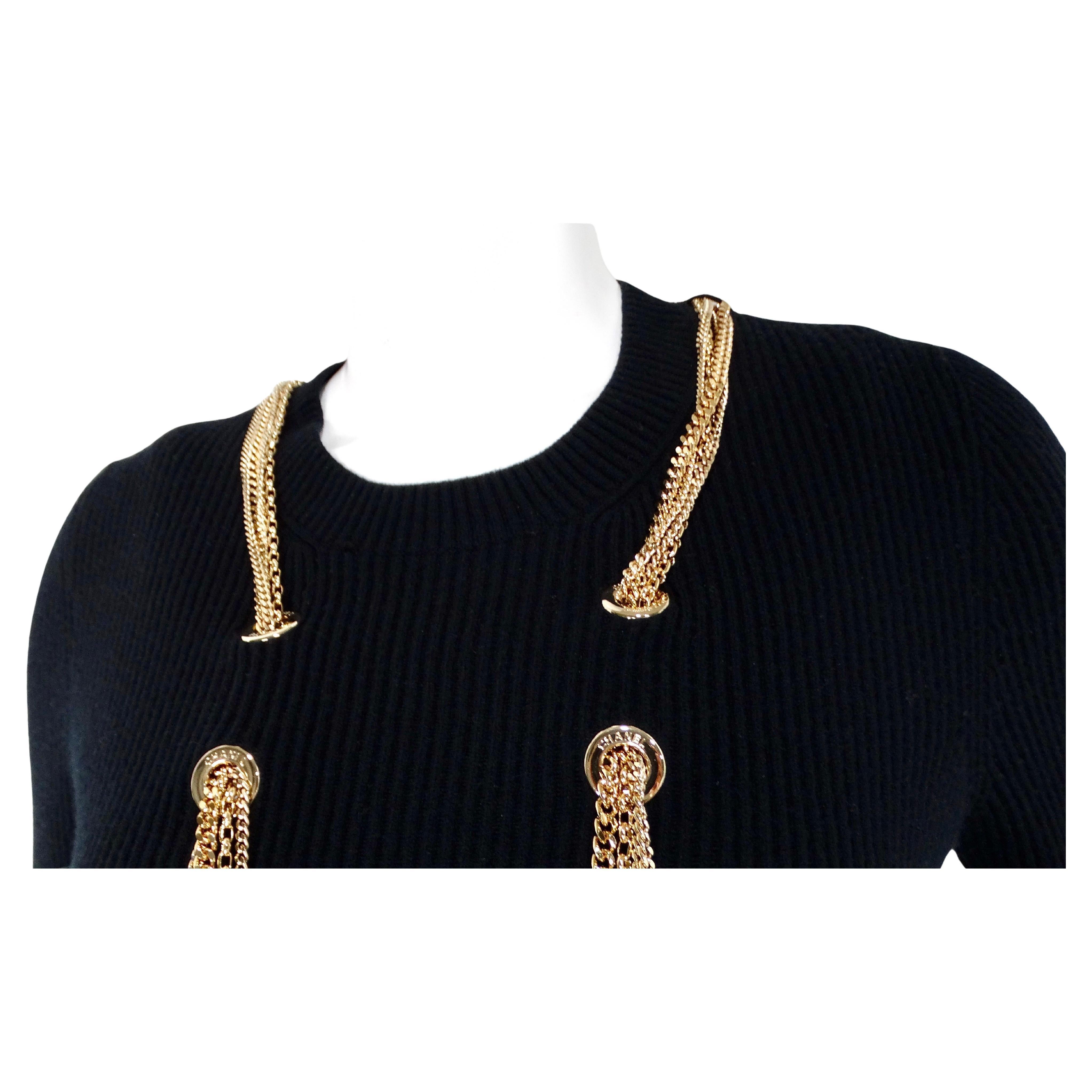Le top en laine côtelée à chaînes CC imbriquées noir et or de Chanel incarne le luxe et le style sophistiqué. Confectionné en laine noire élégante, ce haut à manches courtes en tricot côtelé offre une coupe chic et confortable. La caractéristique