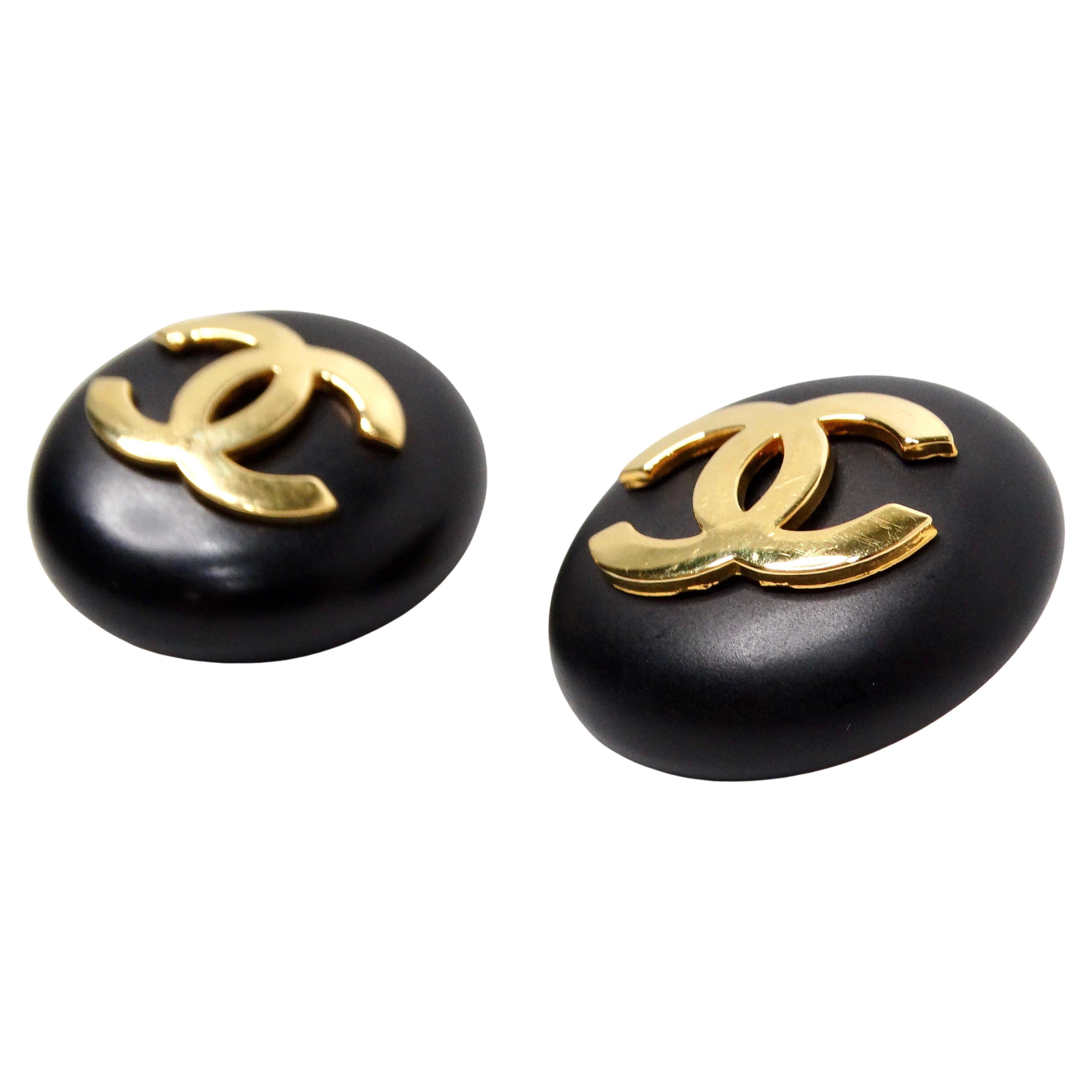 The 1989 Chanel Black & Gold Tone Interlocking CC Round Clip-On Earrings are a stunning statement piece that effortlessly exudes timeless elegance and sophistication. Crafted with a yellow gold-tone metal, these costume earrings feature the iconic