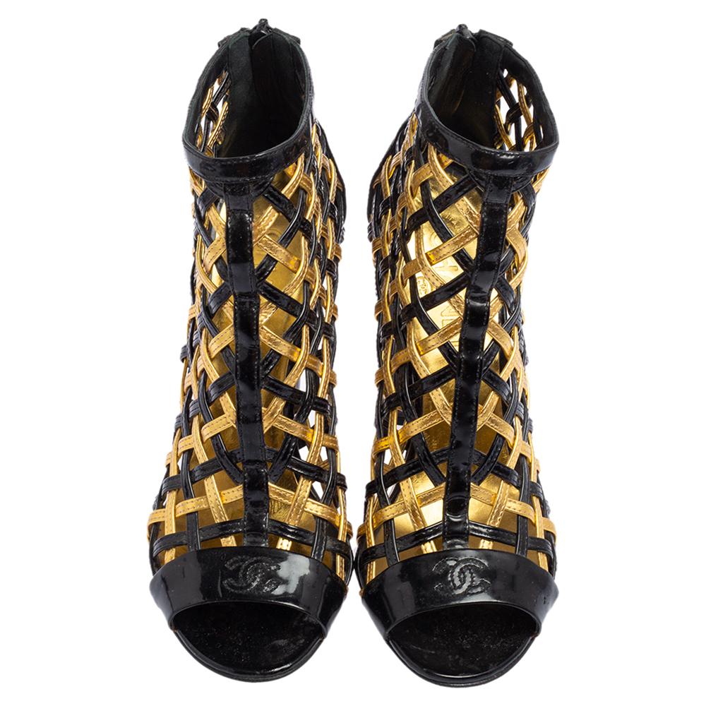 Portati dalla Maison Chanel, questi stivaletti possono rinnovare il tuo look in pochi secondi! La vernice nero-oro e i materiali in pelle sono utilizzati per formare un motivo a gabbia intrecciato sulla tomaia. Inoltre, sfoggiano tacchi a spillo di